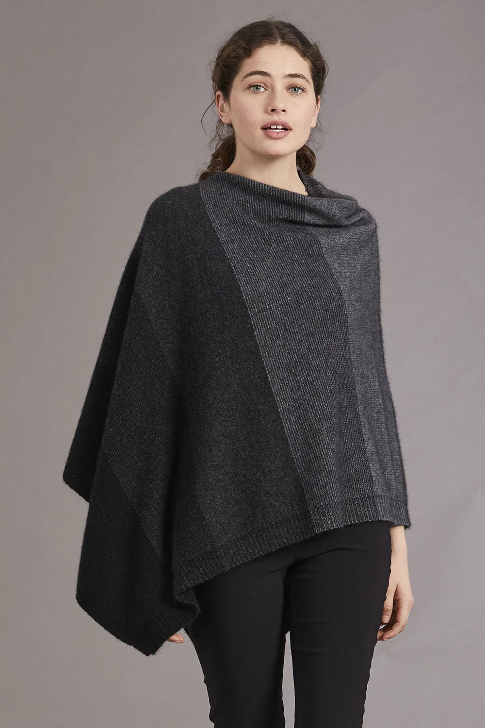 Charcoal grey wool poncho worn over black pants, front view on neutral background. - Yellow Earth Australia