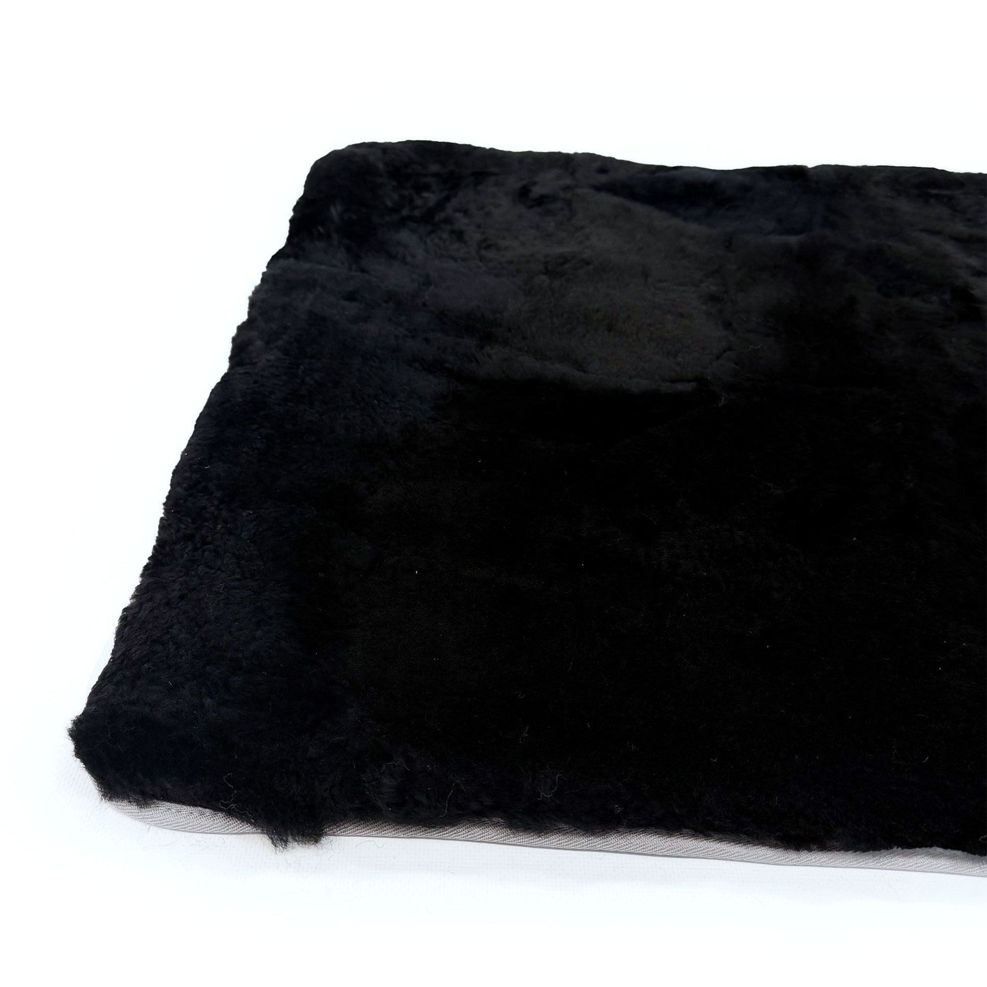 Black sheepskin rug with soft wool pile shown from above angle. - Yellow Earth Australia