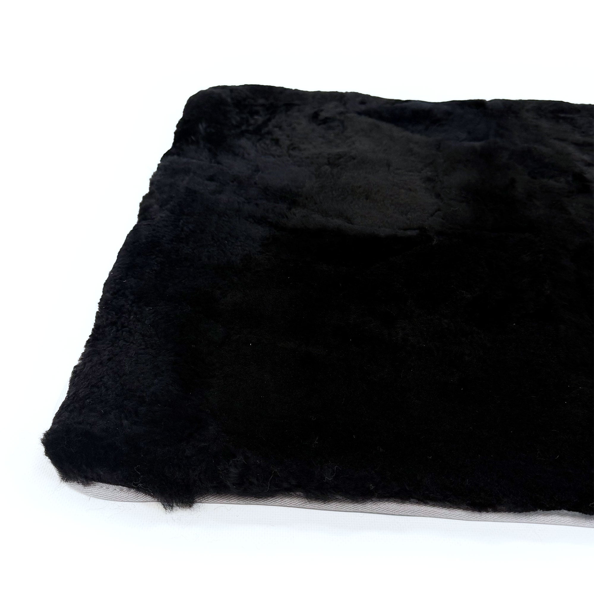 Black sheepskin rug with soft wool pile shown from above angle. - Yellow Earth Australia