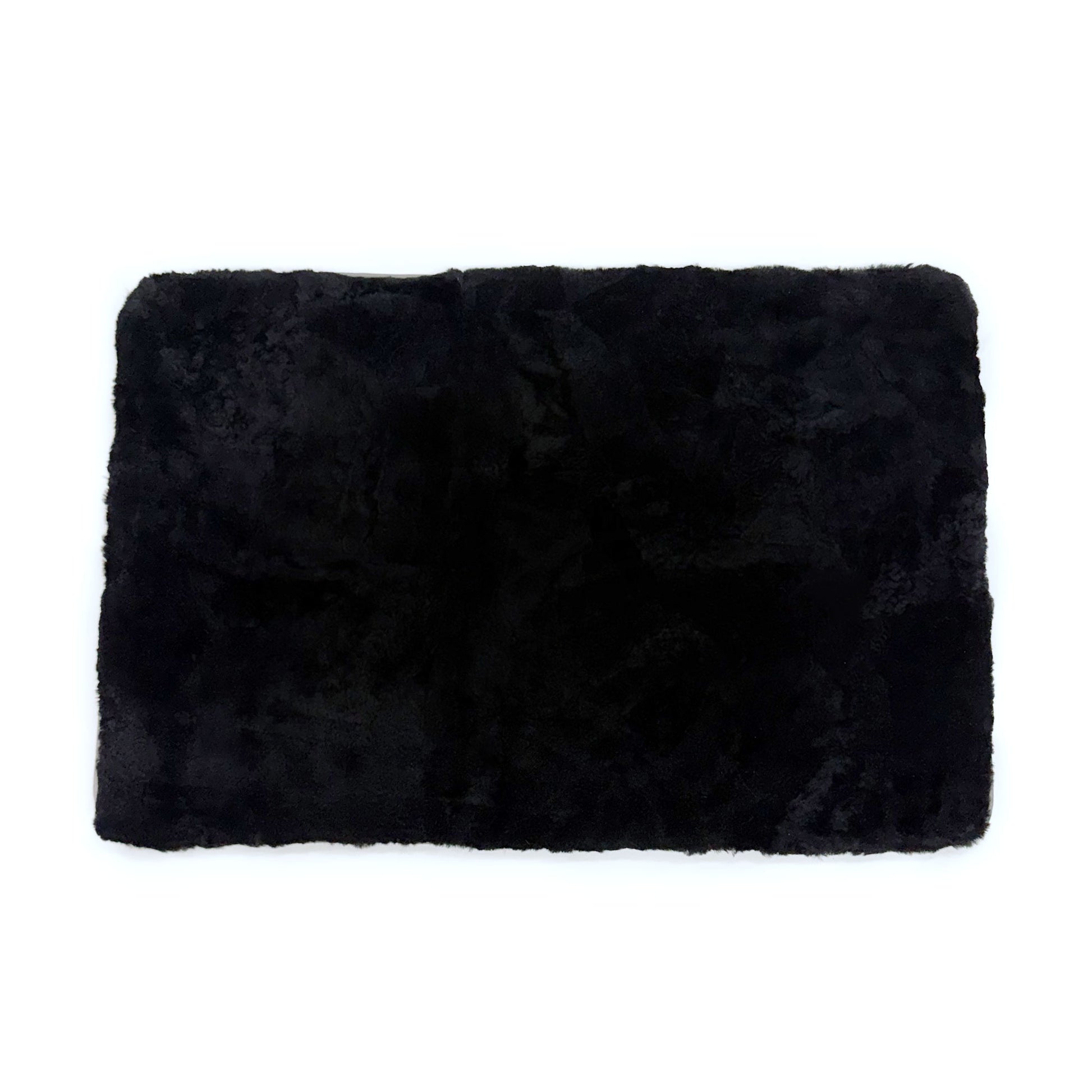 Black sheepskin rug with plush wool pile viewed from above on white background. - Yellow Earth Australia