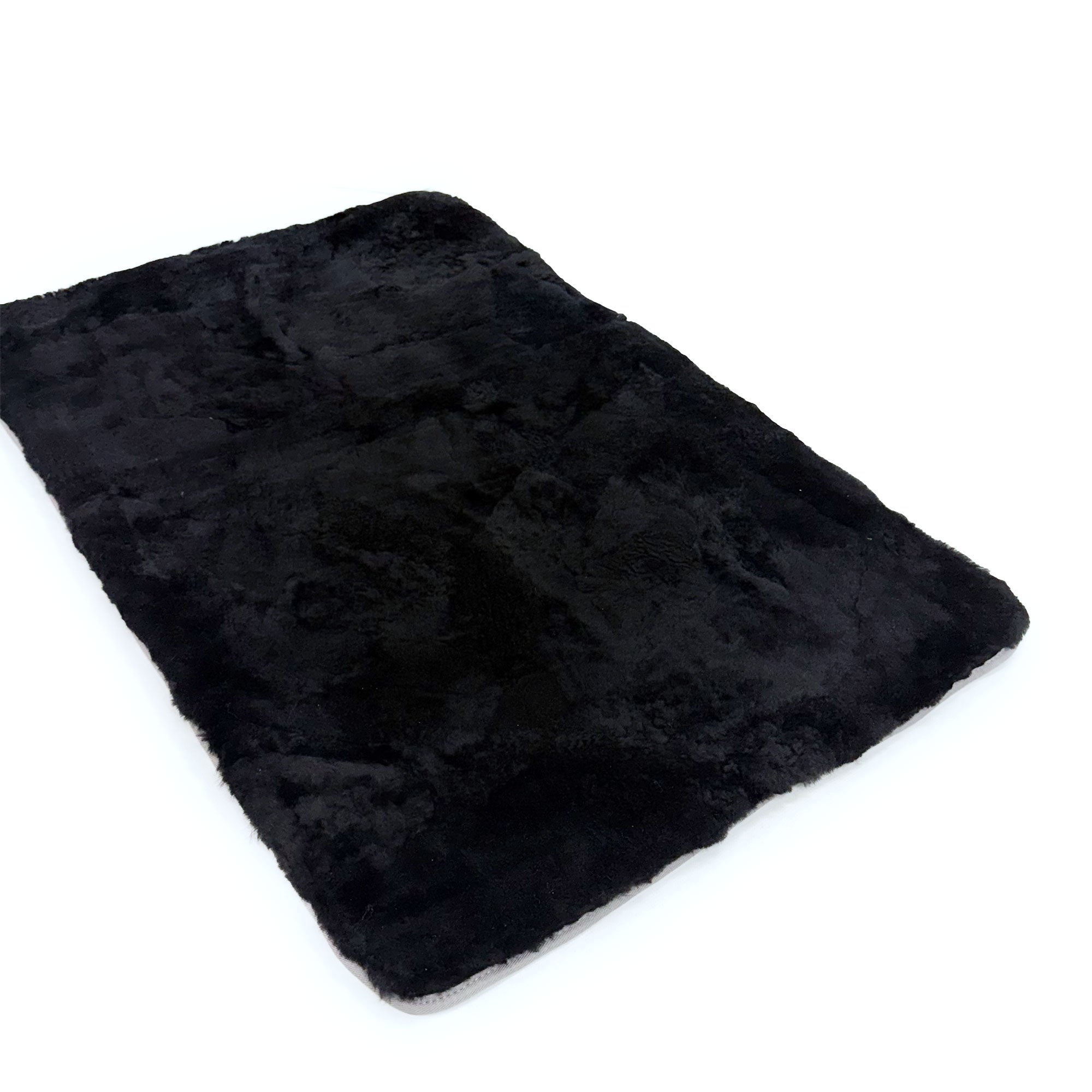 Black sheepskin rug with soft wool texture, viewed from above at an angle. - Yellow Earth Australia