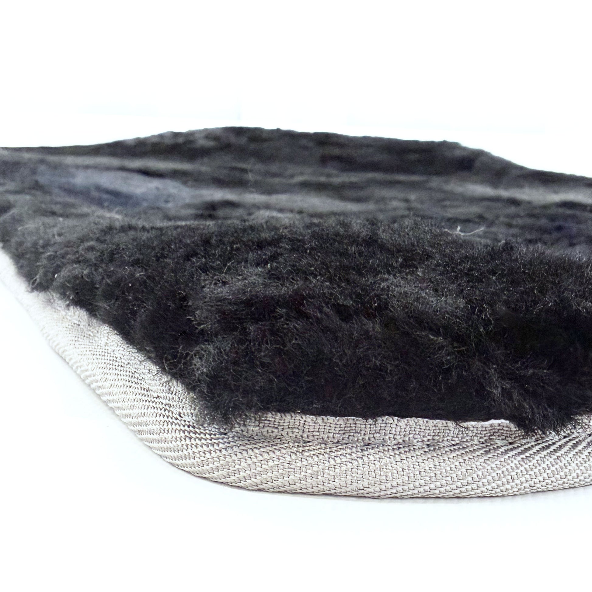 Charcoal sheepskin rug with luxurious wool pile and natural backing, side angle view. - Yellow Earth Australia