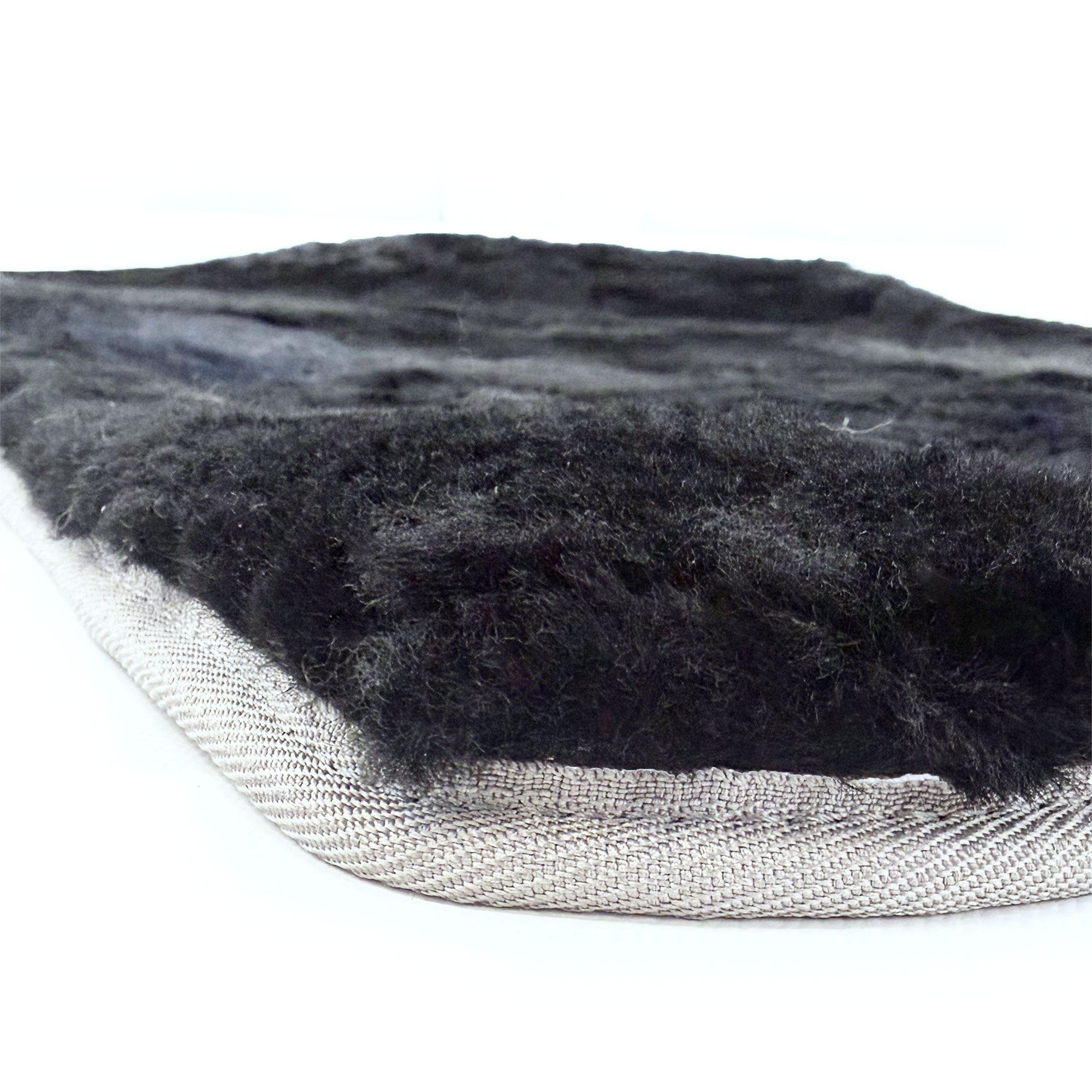 Charcoal sheepskin rug with luxurious wool pile and natural backing, side angle view. - Yellow Earth Australia