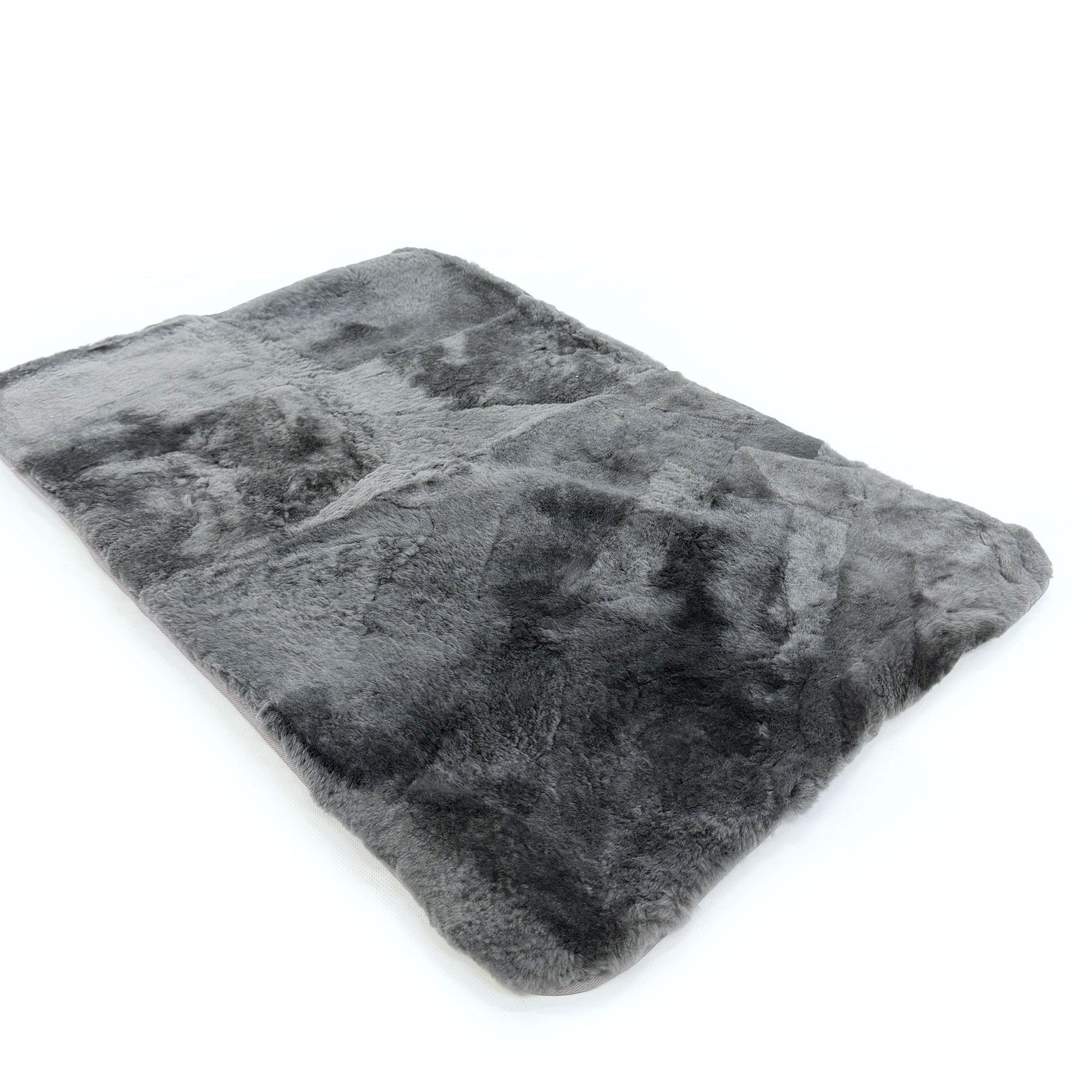 Grey sheepskin rug with natural wool texture viewed from above angle. - Yellow Earth Australia