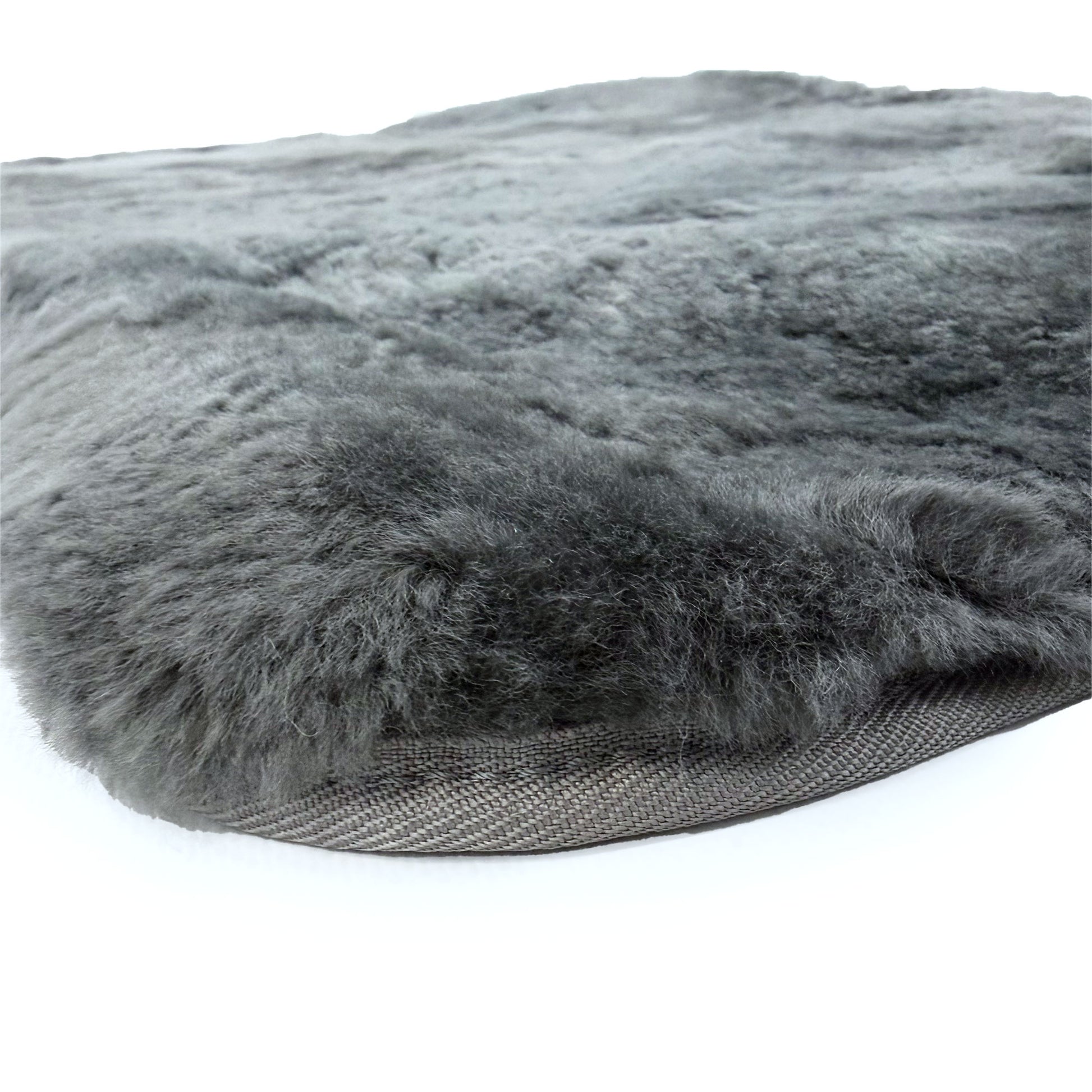 Gray sheepskin rug with wool pile and non-slip backing, angled side view. - Yellow Earth Australia