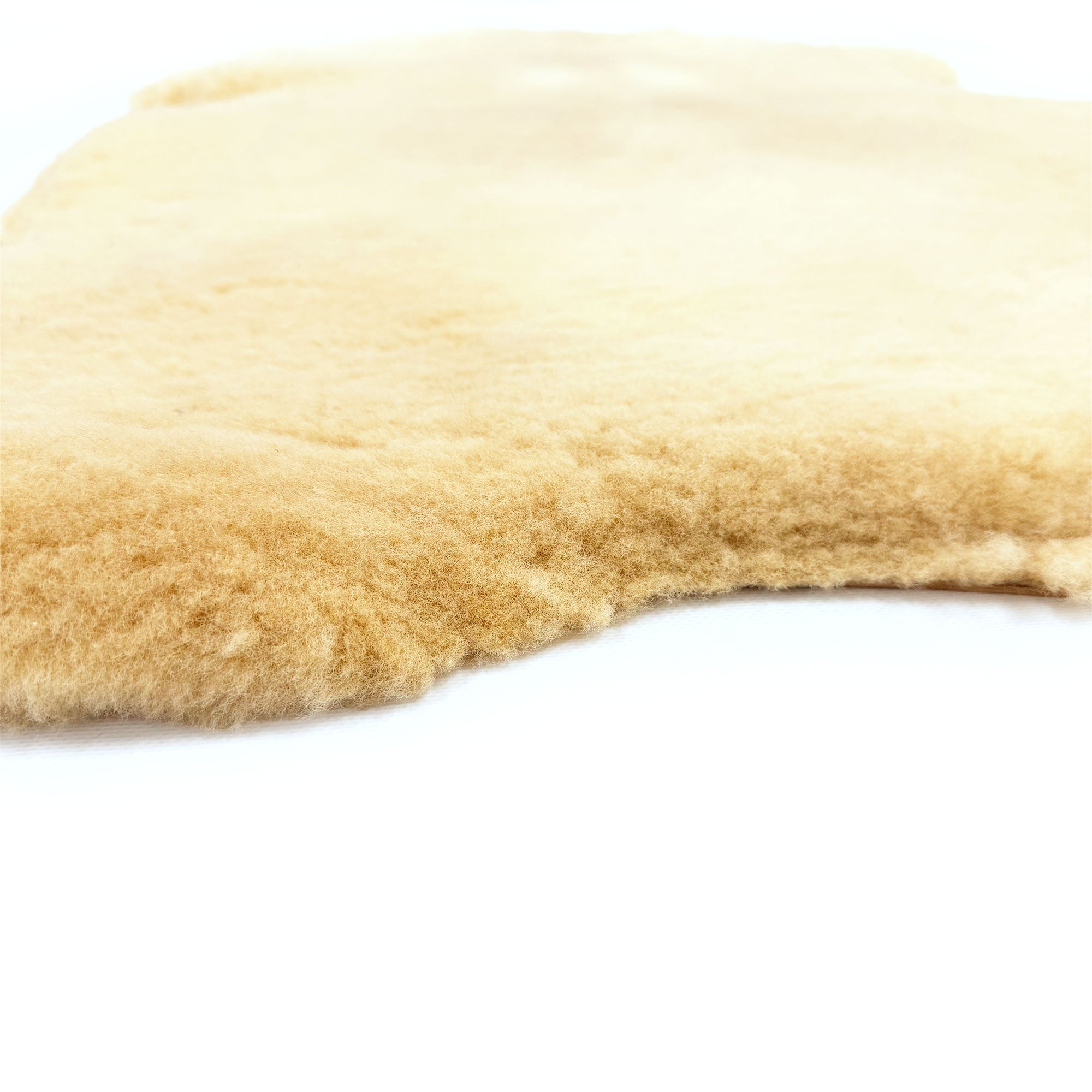 Soft beige sheepskin rug with natural wool texture, angled side view. - Yellow Earth Australia