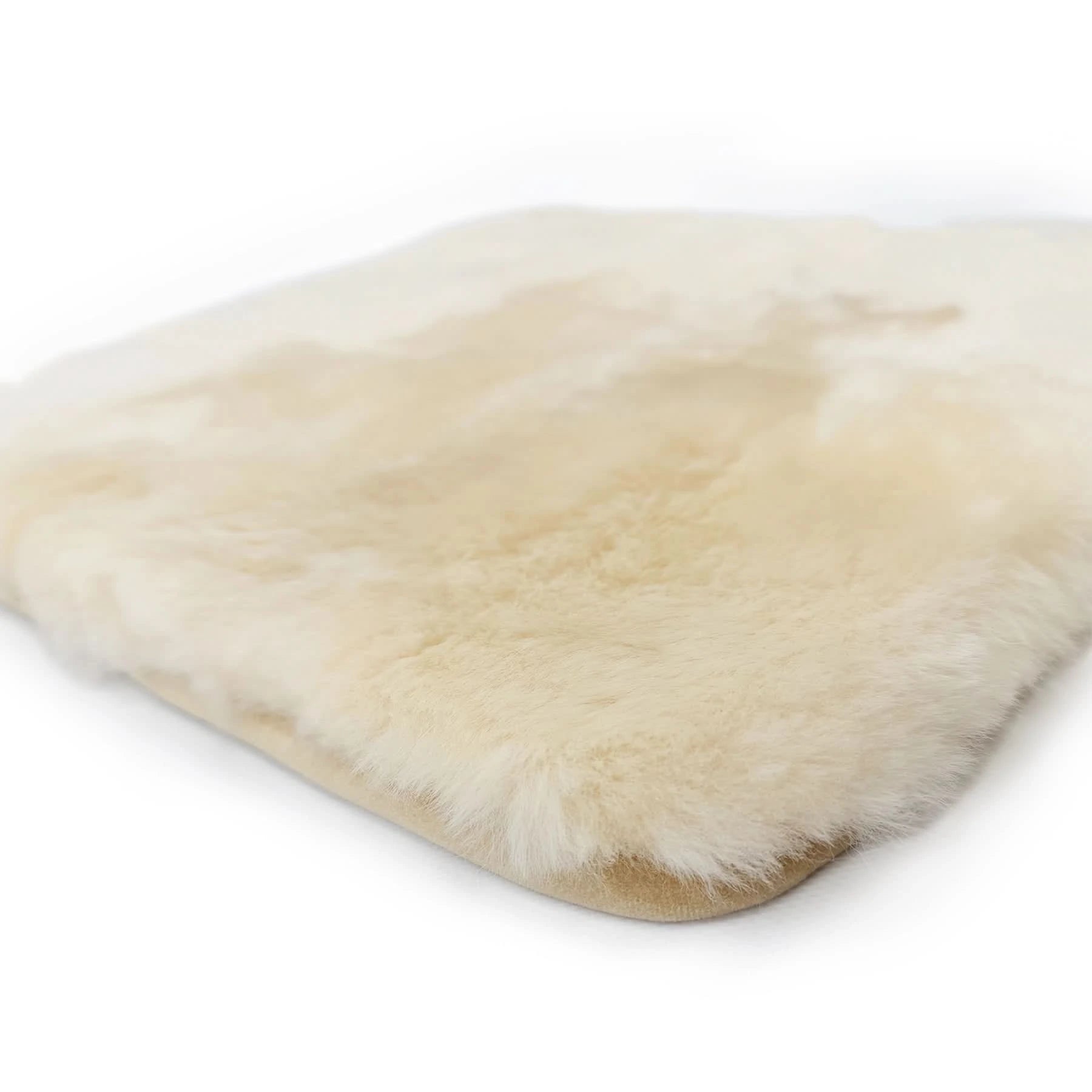 Cream sheepskin rug with soft wool pile viewed from above on white background. - Yellow Earth Australia