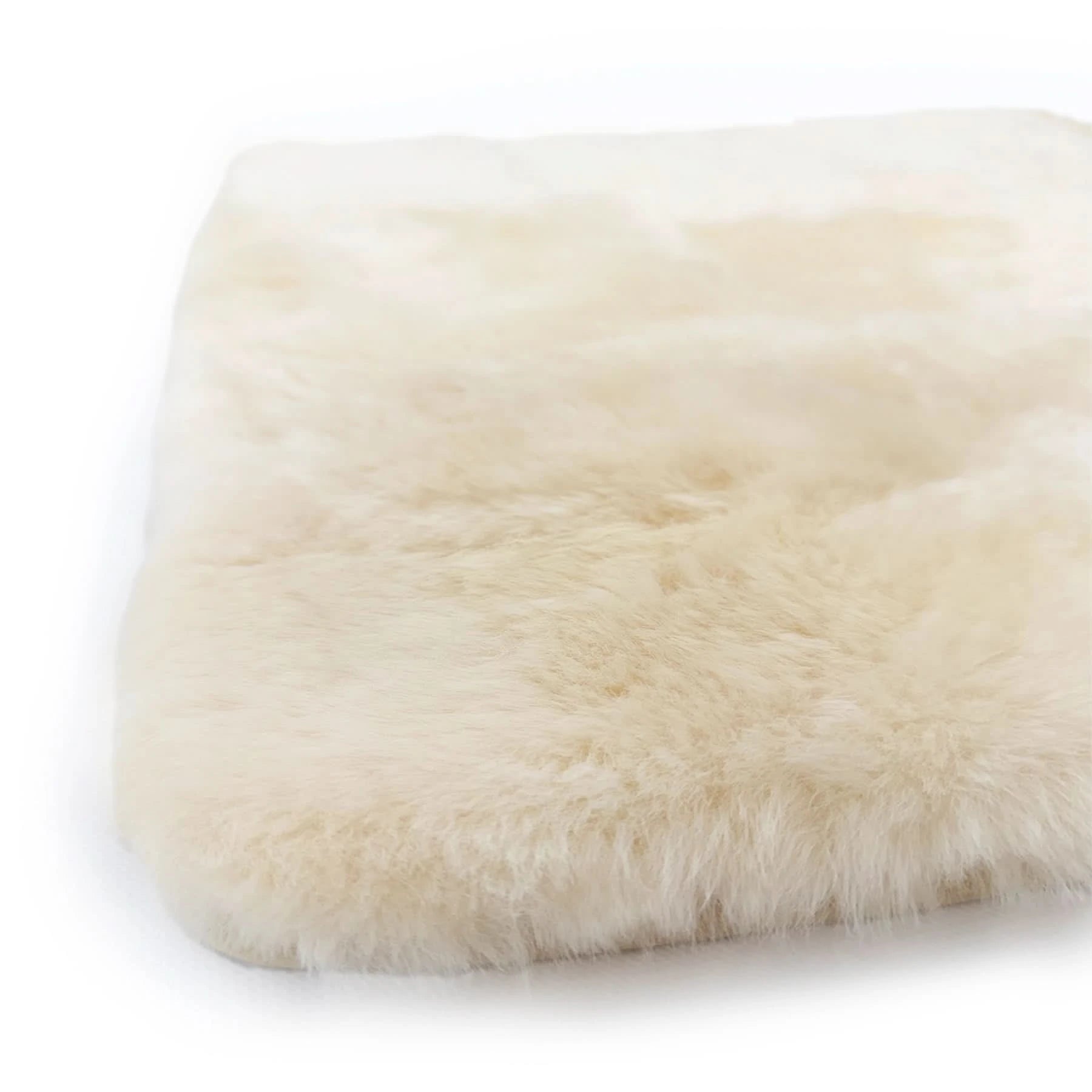 Ivory sheepskin rug with soft fluffy wool texture shown from angled top view. - Yellow Earth Australia