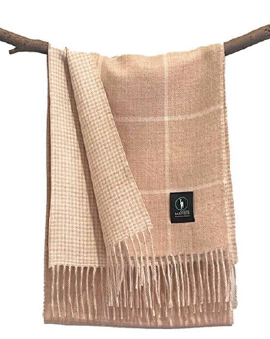 Beige wool throw blanket with checkered pattern and fringe trim draped on branch. - Yellow Earth Australia