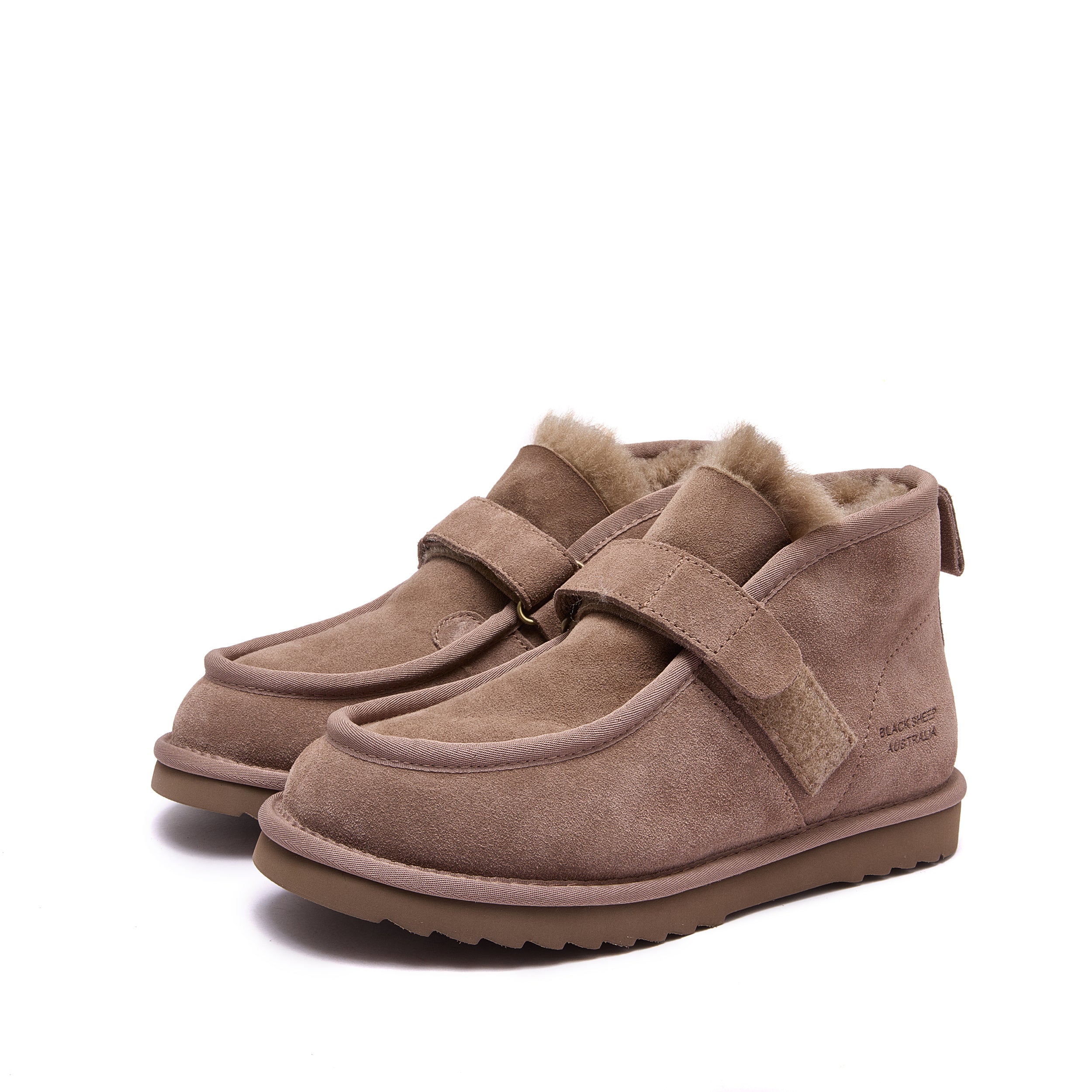 A pair of women's slip-on ankle boots in taupe brown suede, featuring a plush wool lining at the collar, a wide hook-and-loop strap across the instep, and a thick lug sole, shown against a plain white background - Fleece Easy v2 Mushroom