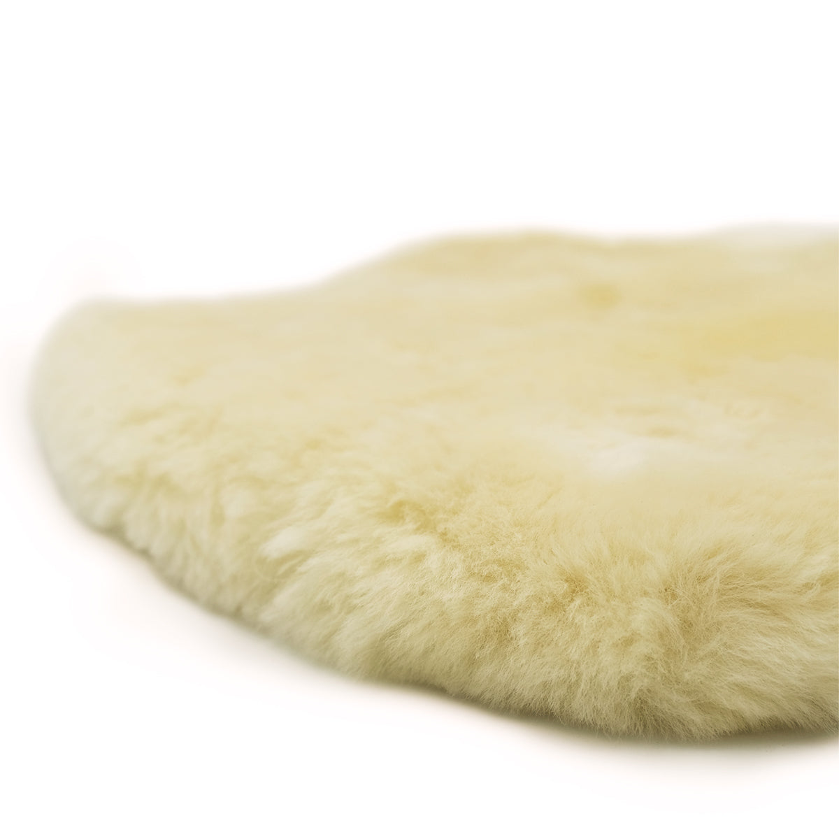 Cream sheepskin rug with soft wool pile viewed from above on white background. - Yellow Earth Australia