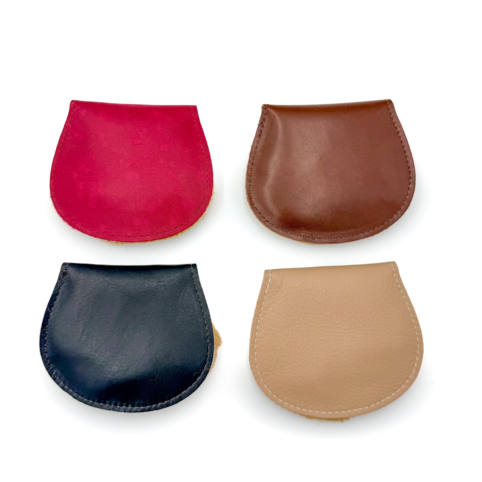 Four flapover purses laid flat, showing the red, brown, black, and tan leather flap colours side by side