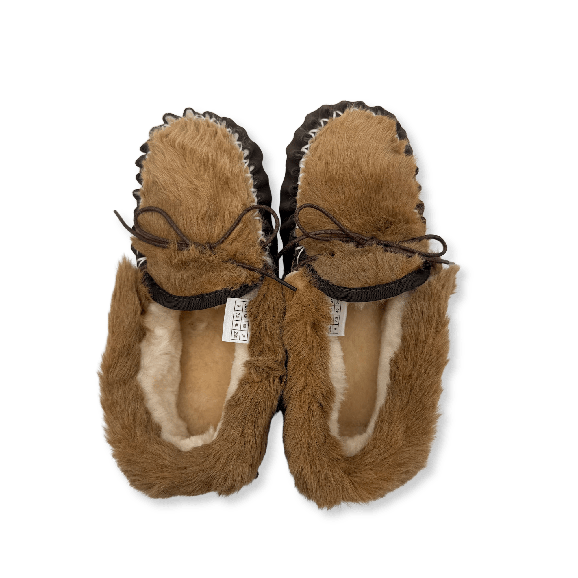 Pair of tan sheepskin slippers with fur lining, viewed from above on white background. - Yellow Earth Australia