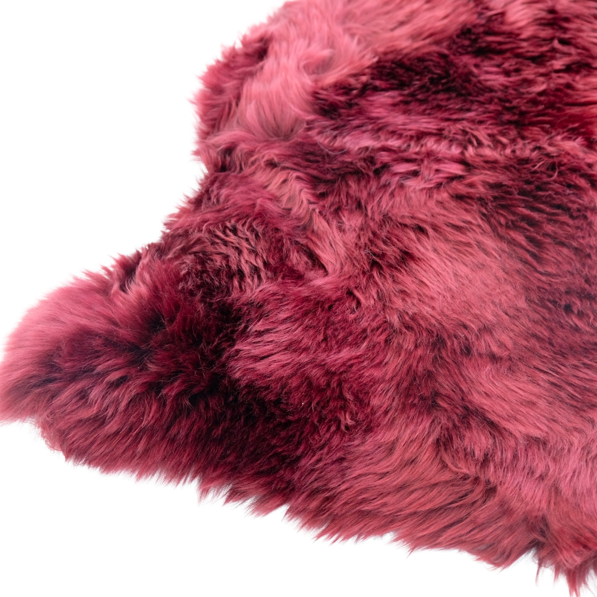 Luxurious pink and burgundy sheepskin rug with soft wool texture, overhead view. - Yellow Earth Australia