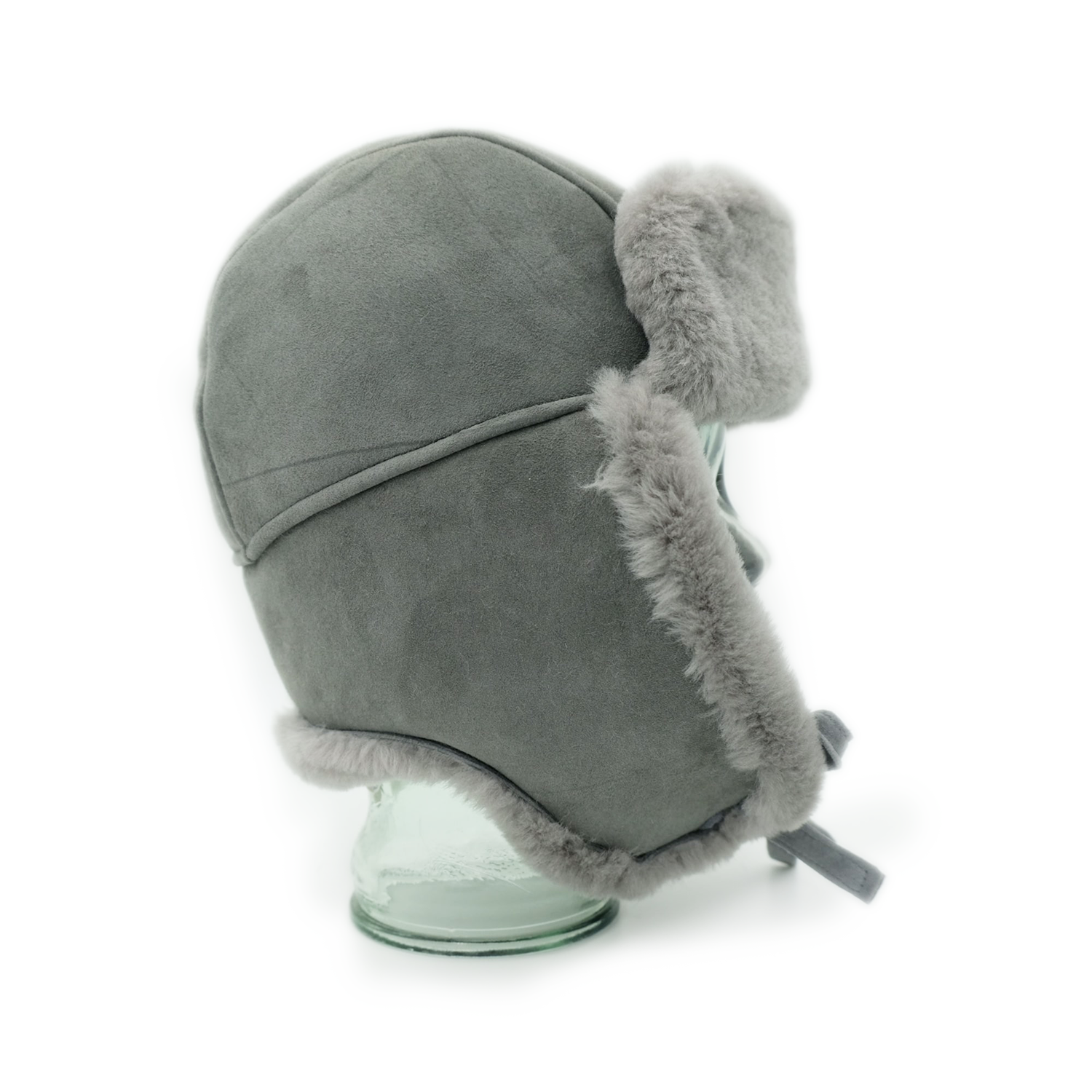 Grey sheepskin trapper hat with fur trim, displayed on stand from side angle. - Yellow Earth Australia