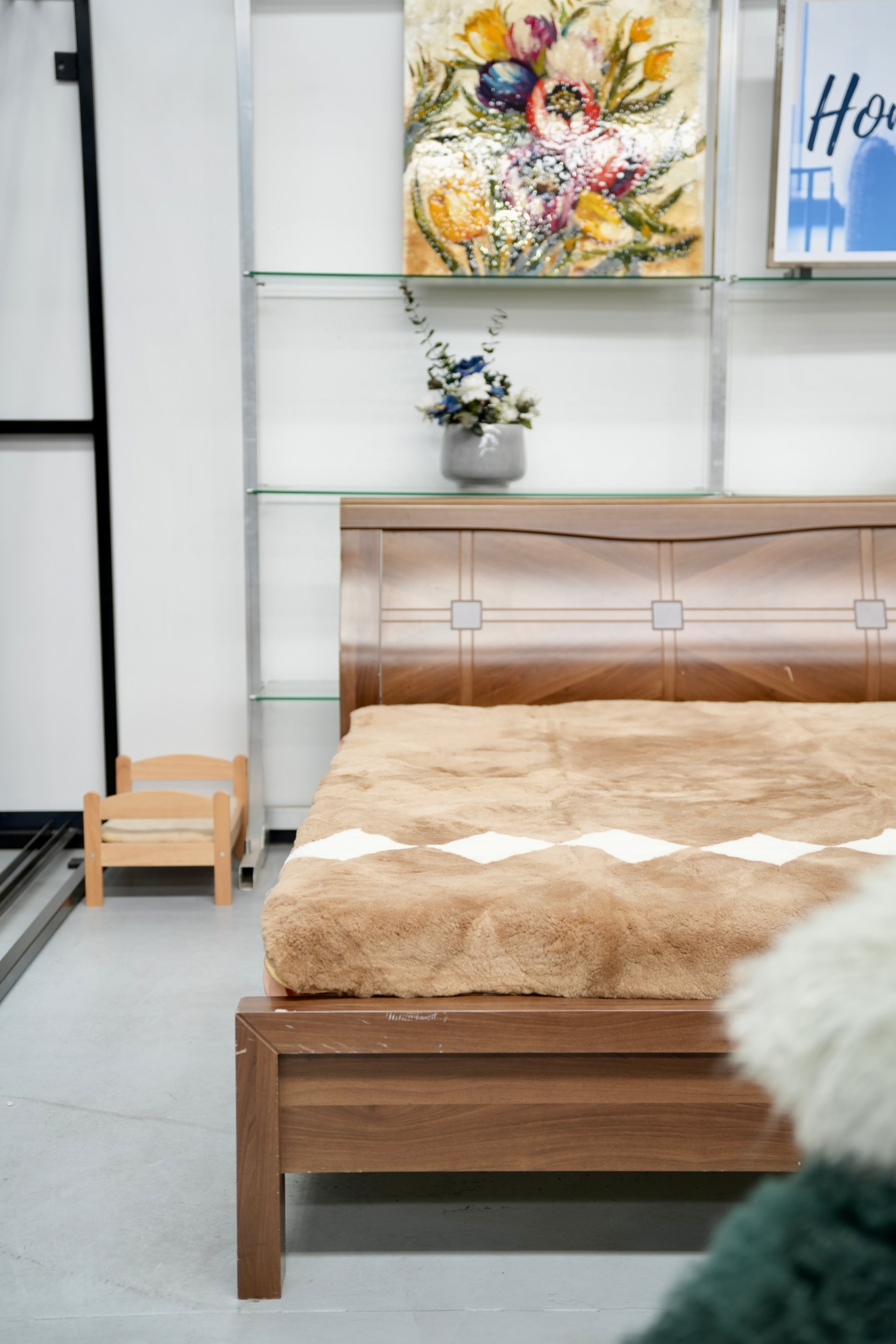 Natural sheepskin bed throw in cream and tan displayed on wooden bed frame. - Yellow Earth Australia