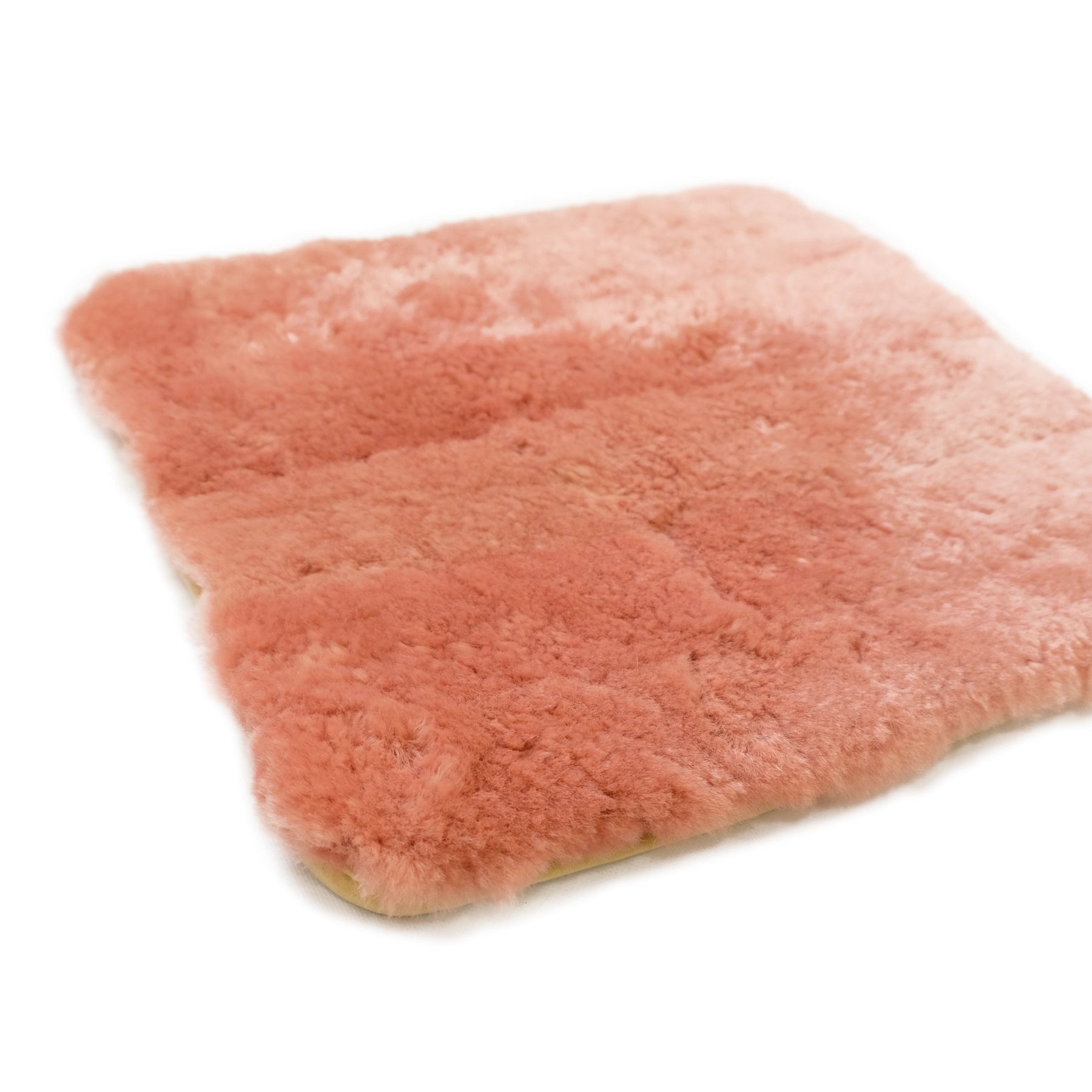 Soft pink sheepskin rug viewed from above showing fluffy wool texture and natural backing. - Yellow Earth Australia