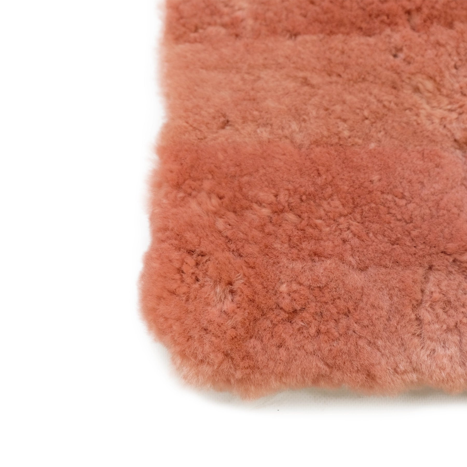 Soft terracotta sheepskin rug with fluffy wool texture viewed from above. - Yellow Earth Australia