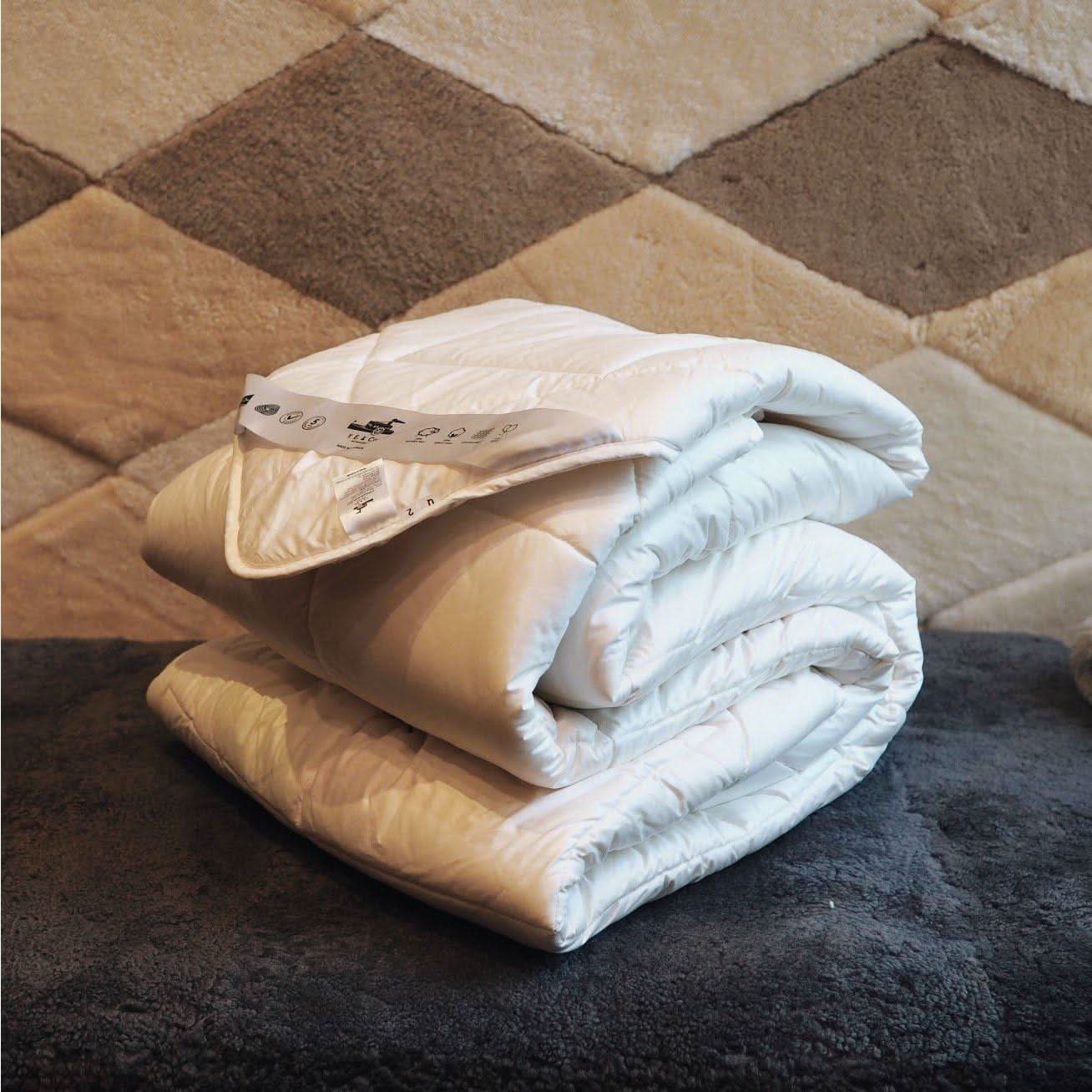 White wool duvet displayed rolled on patterned carpet swatches showing texture and material quality. - Yellow Earth Australia