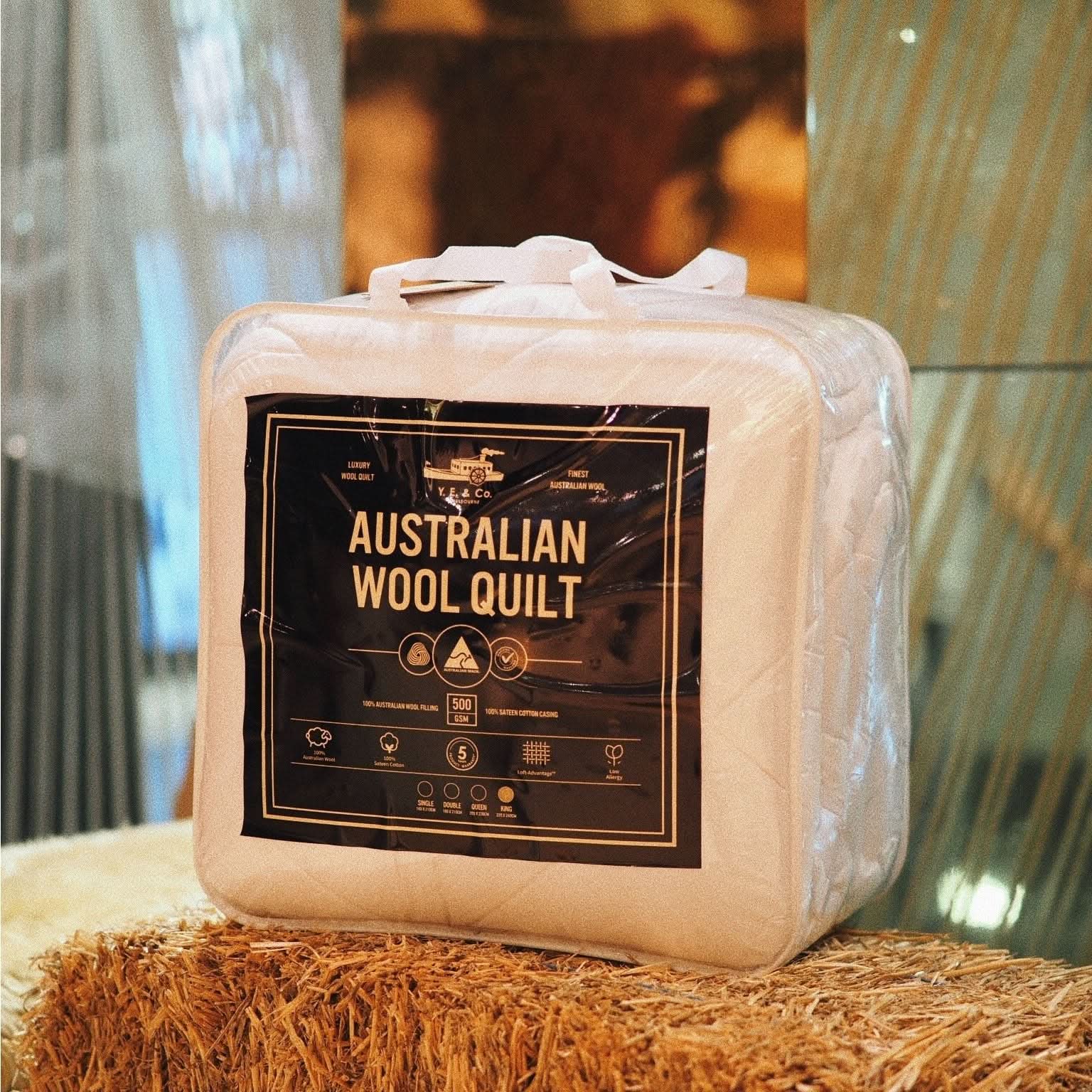 Cream colored Australian wool quilt in vacuum-sealed packaging displayed on natural fiber surface. - Yellow Earth Australia