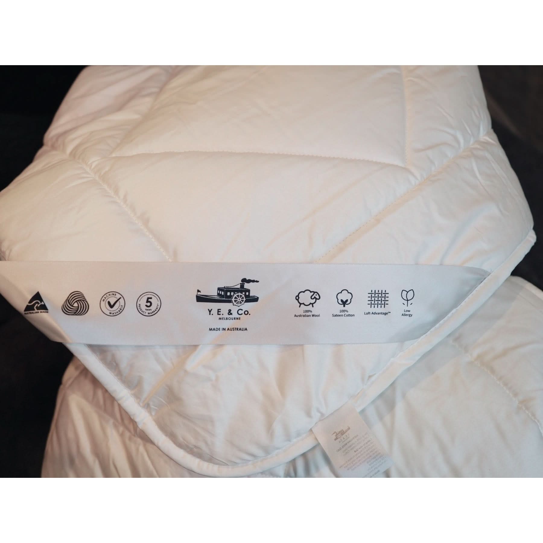 White quilted wool and cotton doona with care label showing Australian manufacturing details. - Yellow Earth Australia