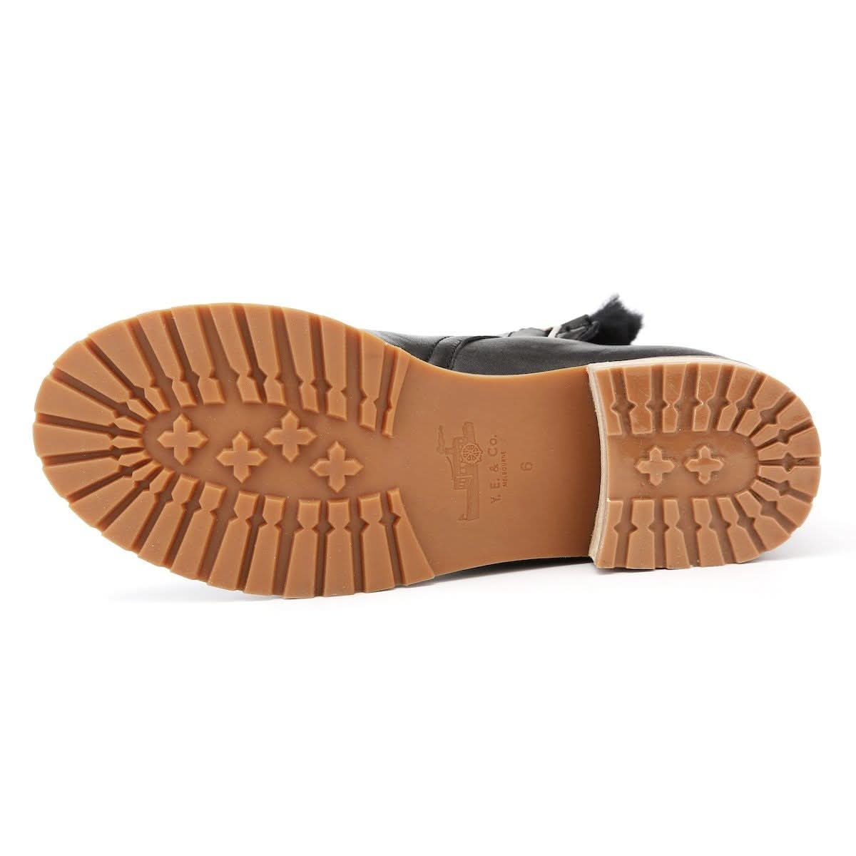 Black sheepskin lace-up boot with tan crepe sole, shown from underside view. - Yellow Earth Australia