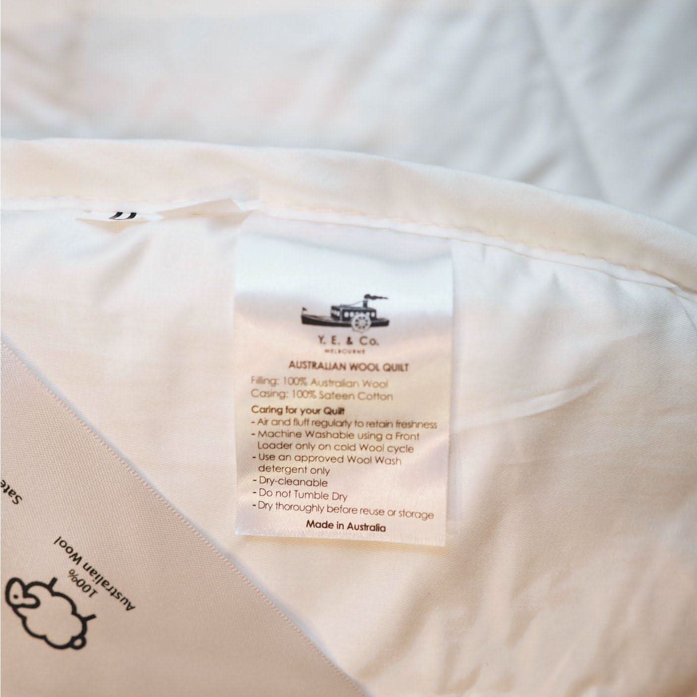 Cream Australian wool quilt with sateen cotton casing and care label detail visible. - Yellow Earth Australia