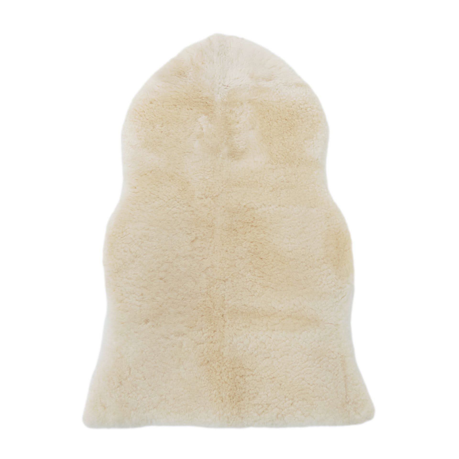 Cream sheepskin rug with natural wool pile viewed from above on white background. - Yellow Earth Australia
