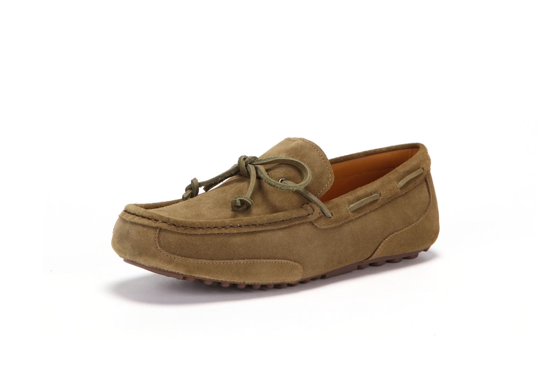 Tan suede men's moccasin with rubber sole and lace detailing on a white background