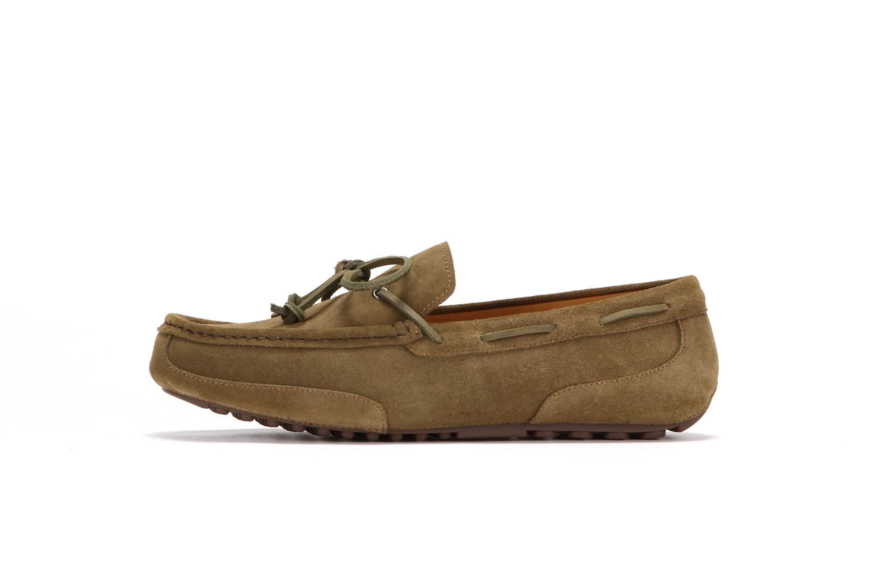 Tan suede men's moccasin with rubber sole and leather lace, side profile on white background