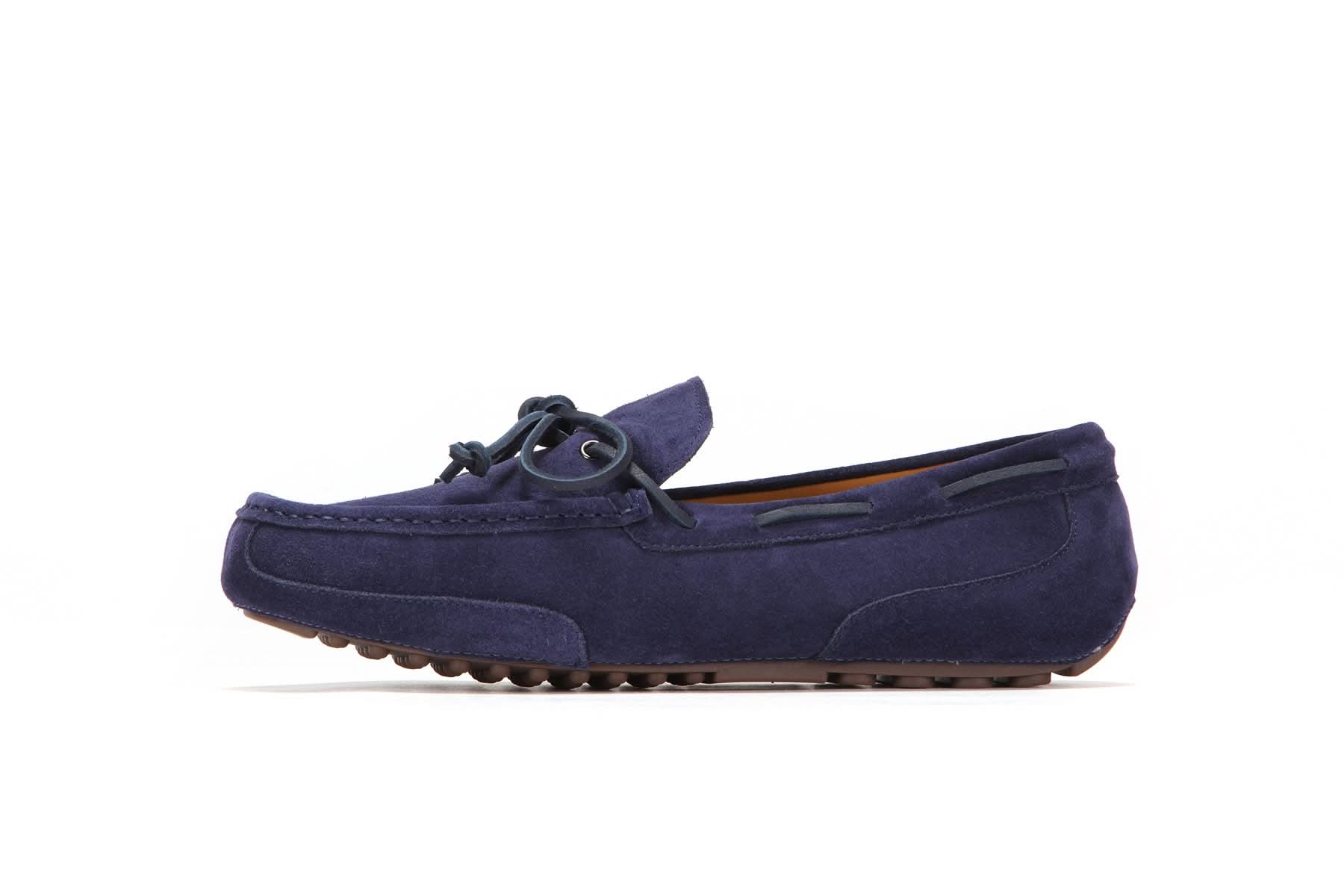 Navy suede men’s moccasin with rubber sole and lace detail on white background