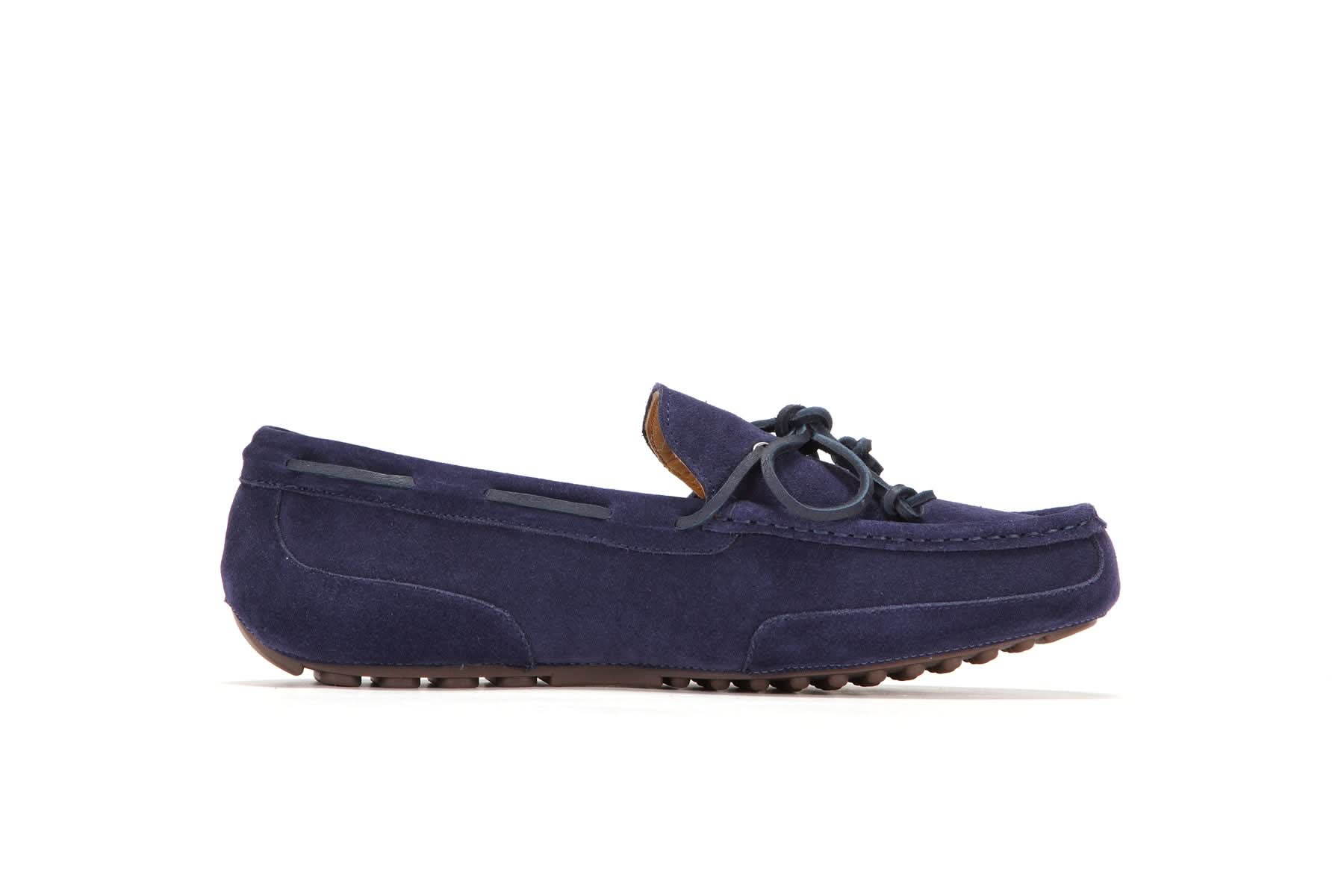 Navy blue suede men's moccasin with rubber sole and lace detail, side view, on white background