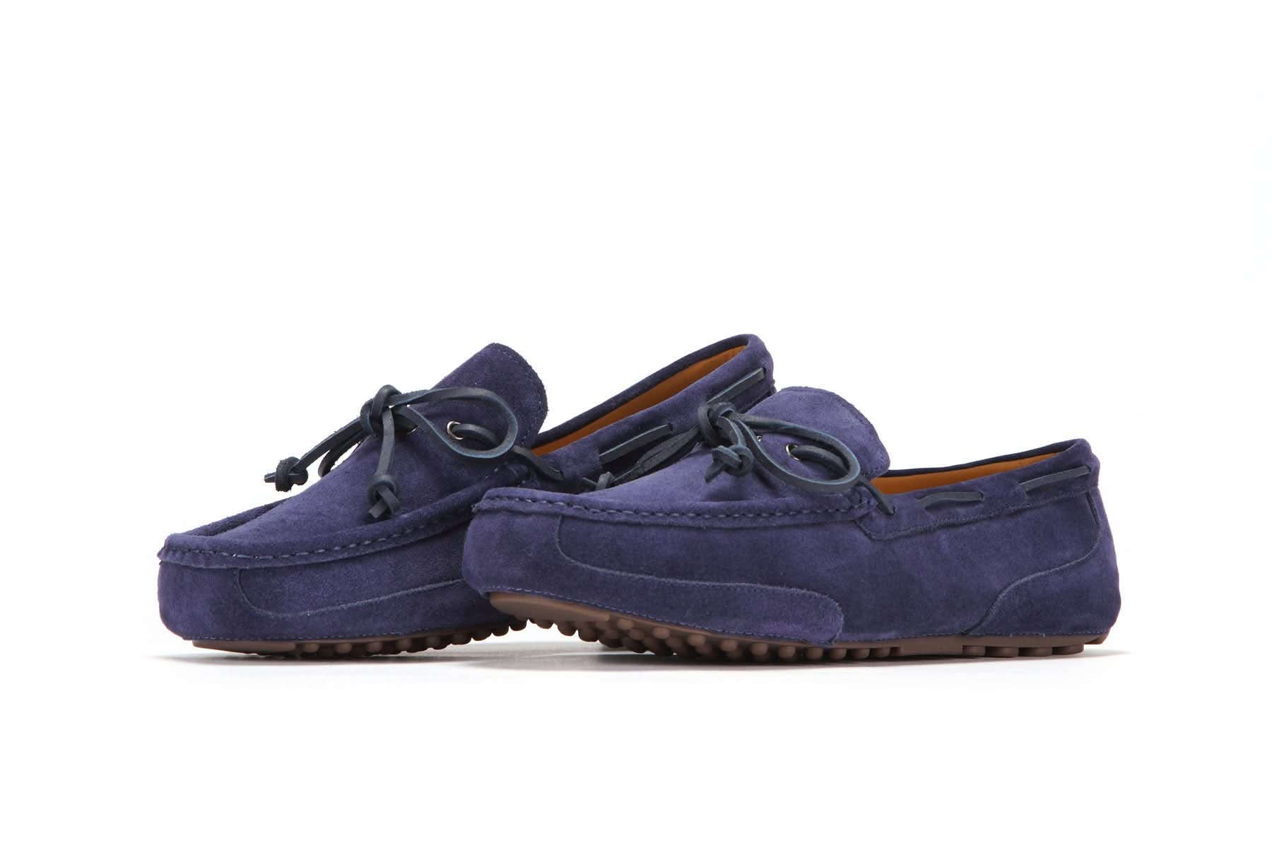 Pair of navy blue suede moccasin slippers with rubber soles and decorative laces