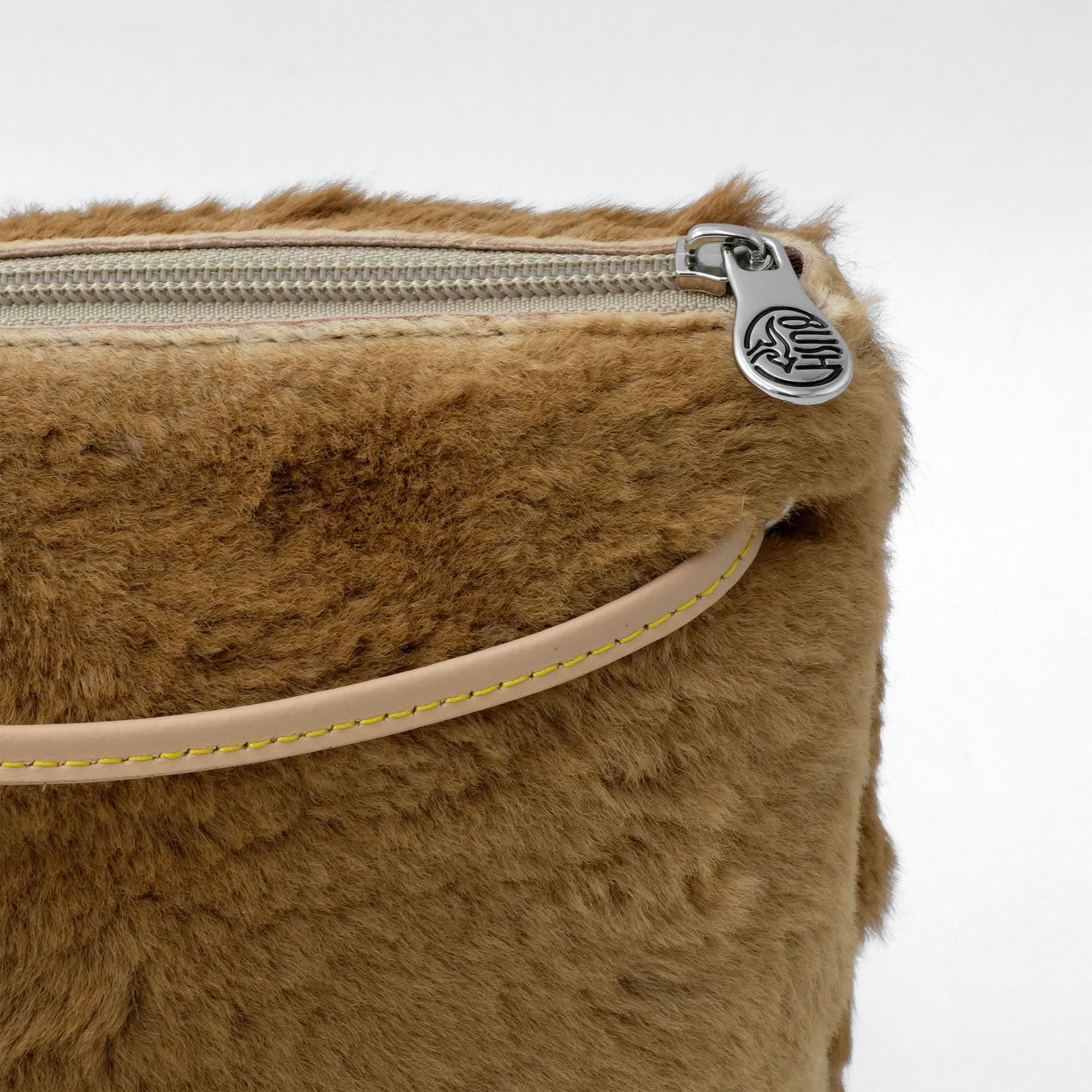 Caramel sheepskin pouch with metal zip and tan leather handle, top view. - Yellow Earth Australia