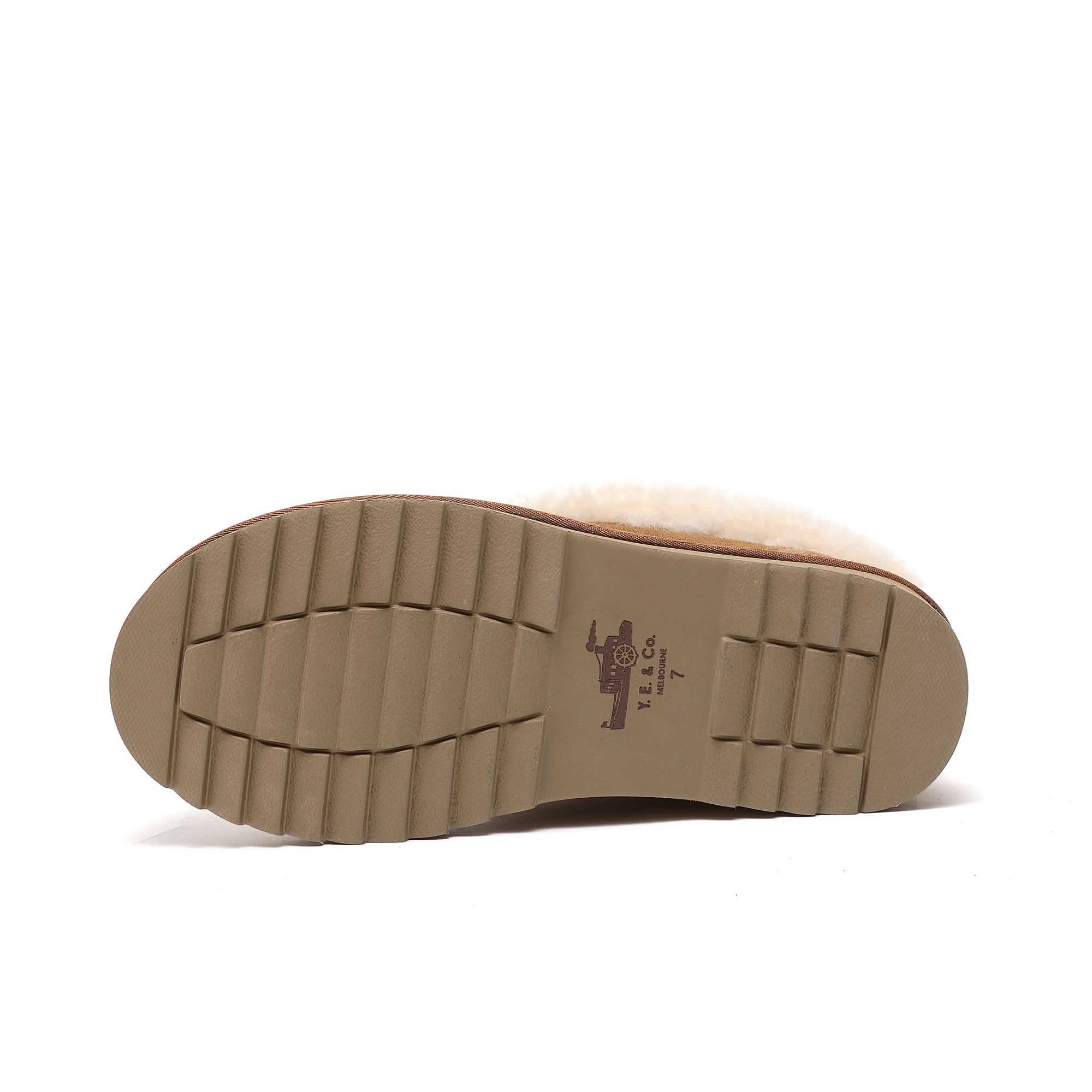 Beige rubber sole of a sheepskin boot with tread pattern, displayed on a white background.