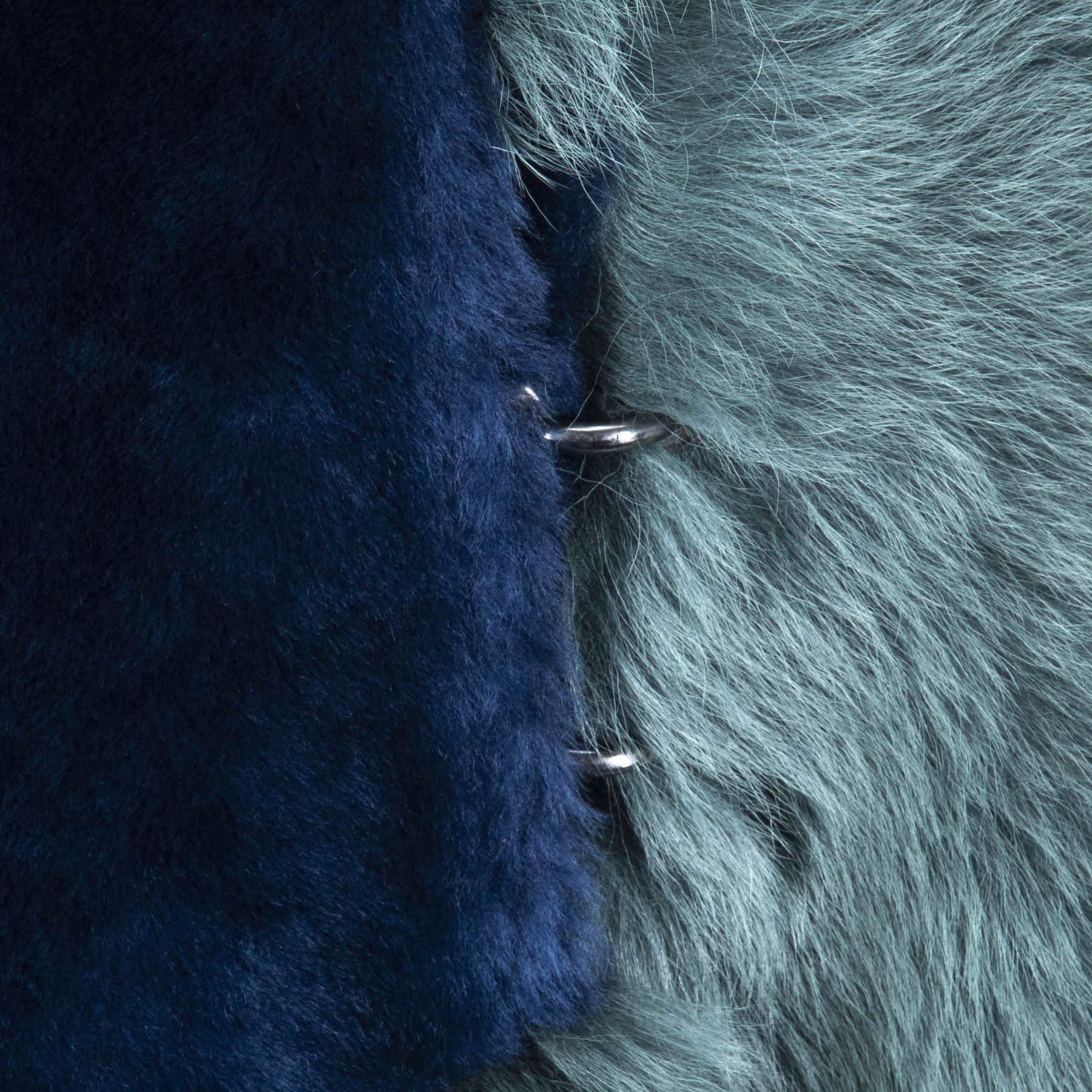Close-up of dark navy and grey sheepskin with visible wool texture and metal fasteners. - Yellow Earth Australia