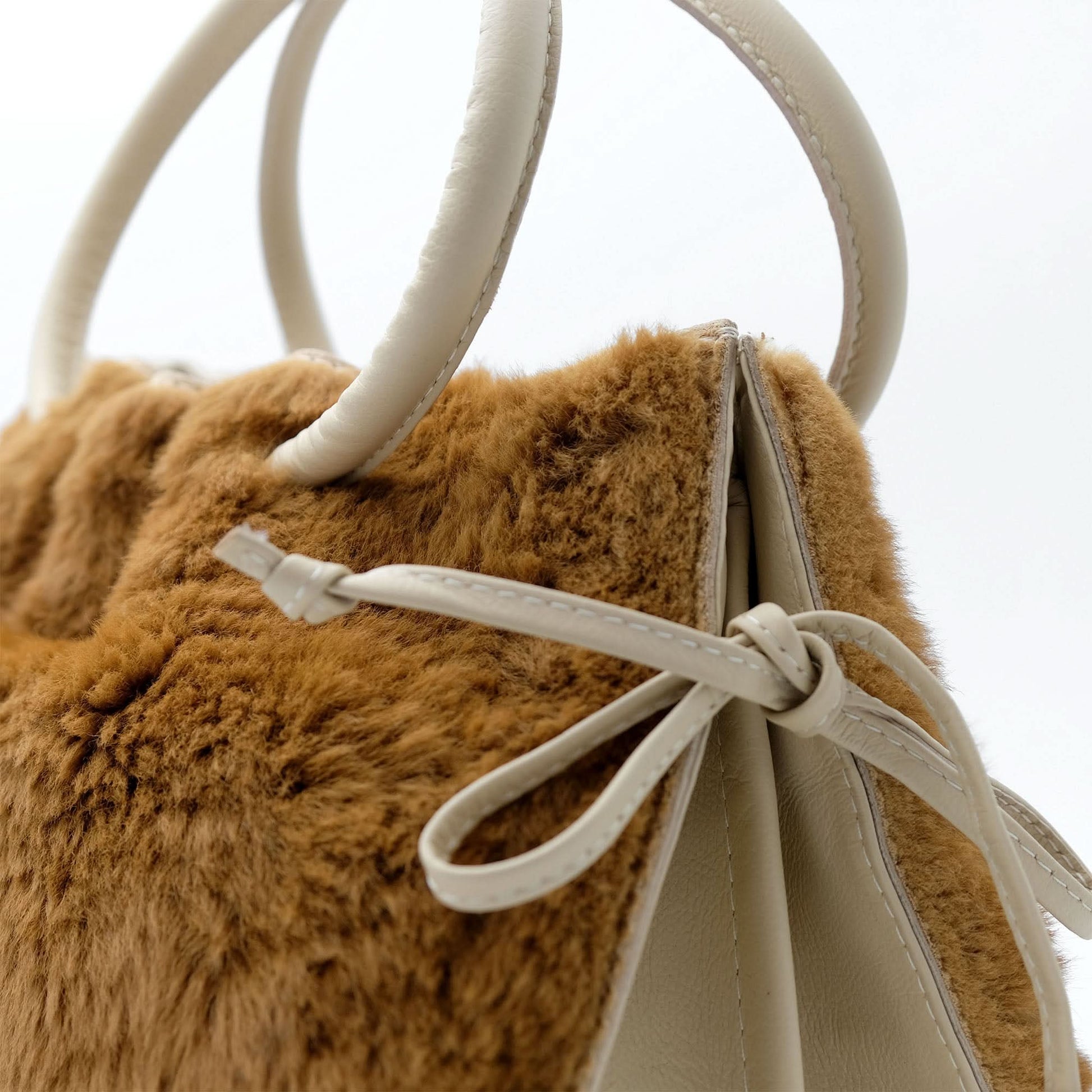 Caramel sheepskin handbag with cream leather handles, close-up detail view. - Yellow Earth Australia
