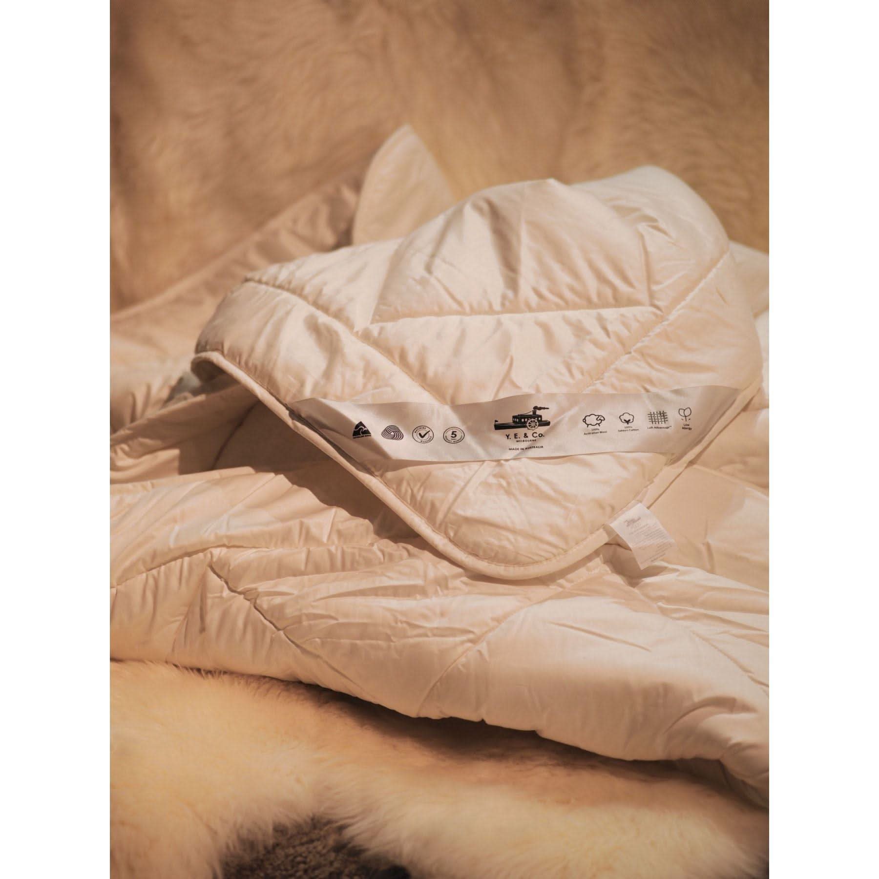Cream quilted wool bedding with care symbols displayed on label, top view. - Yellow Earth Australia
