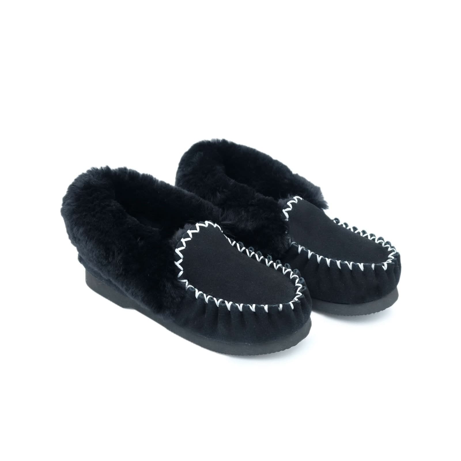 Black sheepskin moccasin slippers with fur lining and whipstitched detail, angled front view. - Yellow Earth Australia