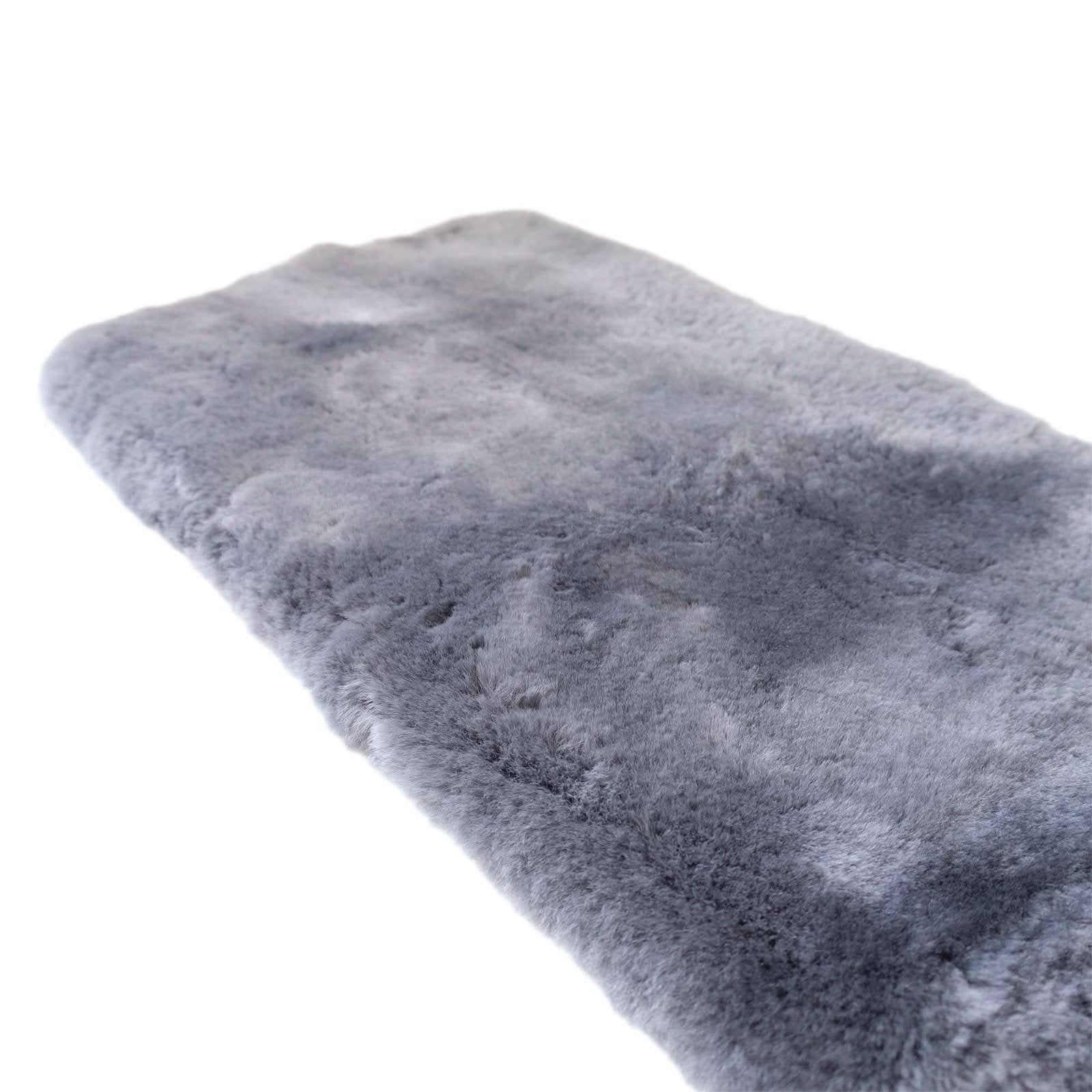 Grey sheepskin rug with soft wool pile texture shown at an angle on white background. - Yellow Earth Australia