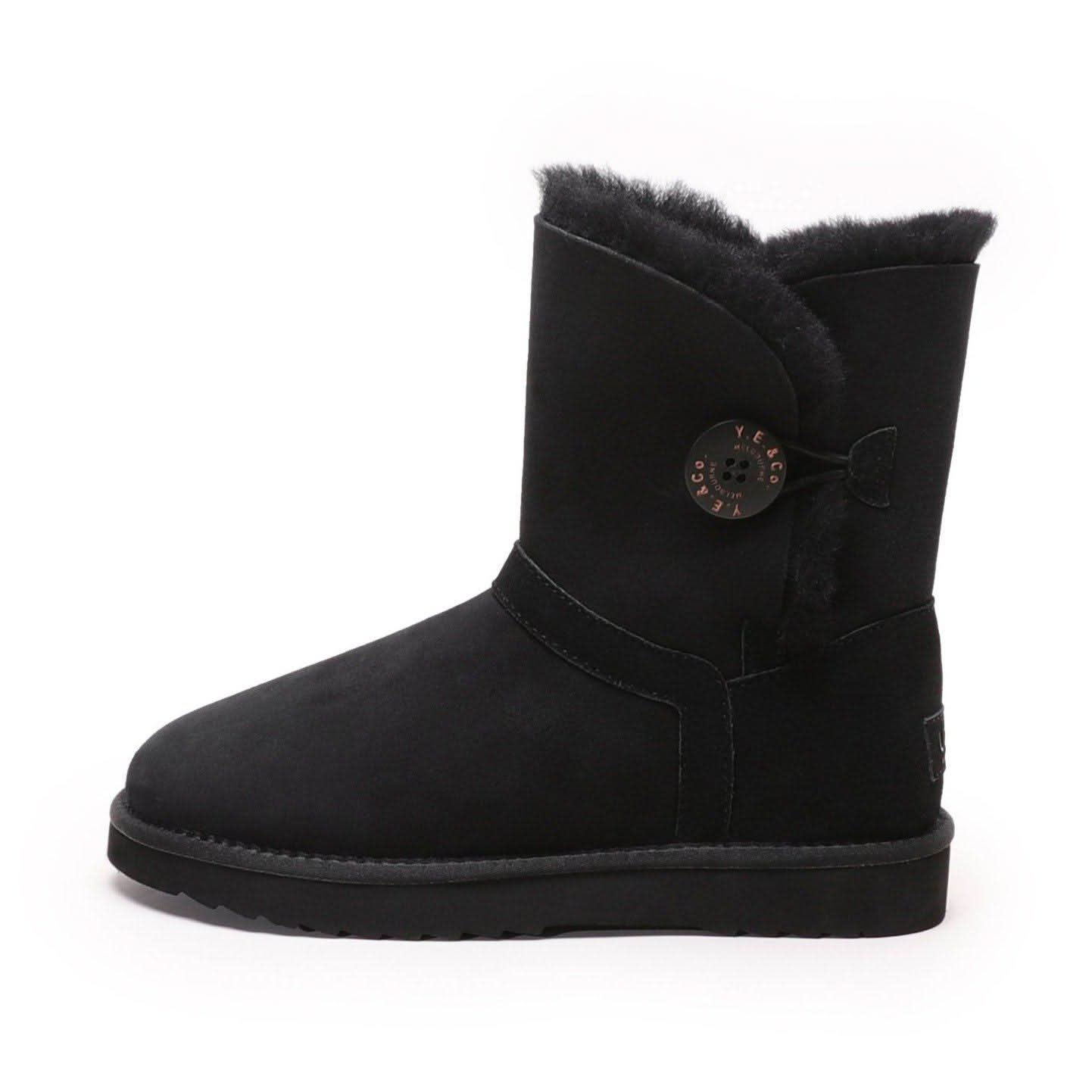 Black sheepskin boot with fur trim and decorative button, side view. - Yellow Earth Australia