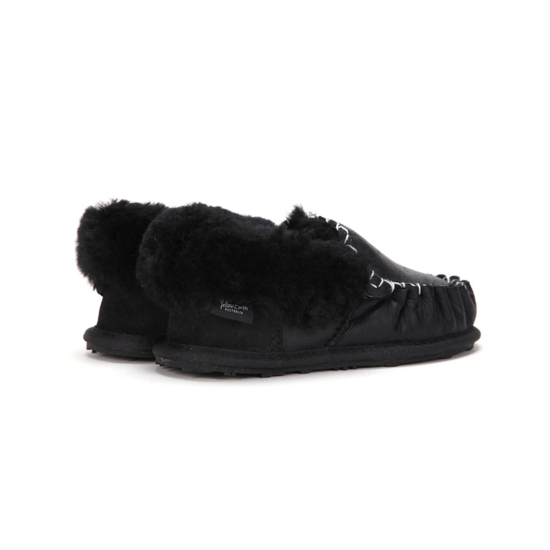 Black sheepskin slipper with fluffy wool lining shown from the side angle. - Yellow Earth Australia
