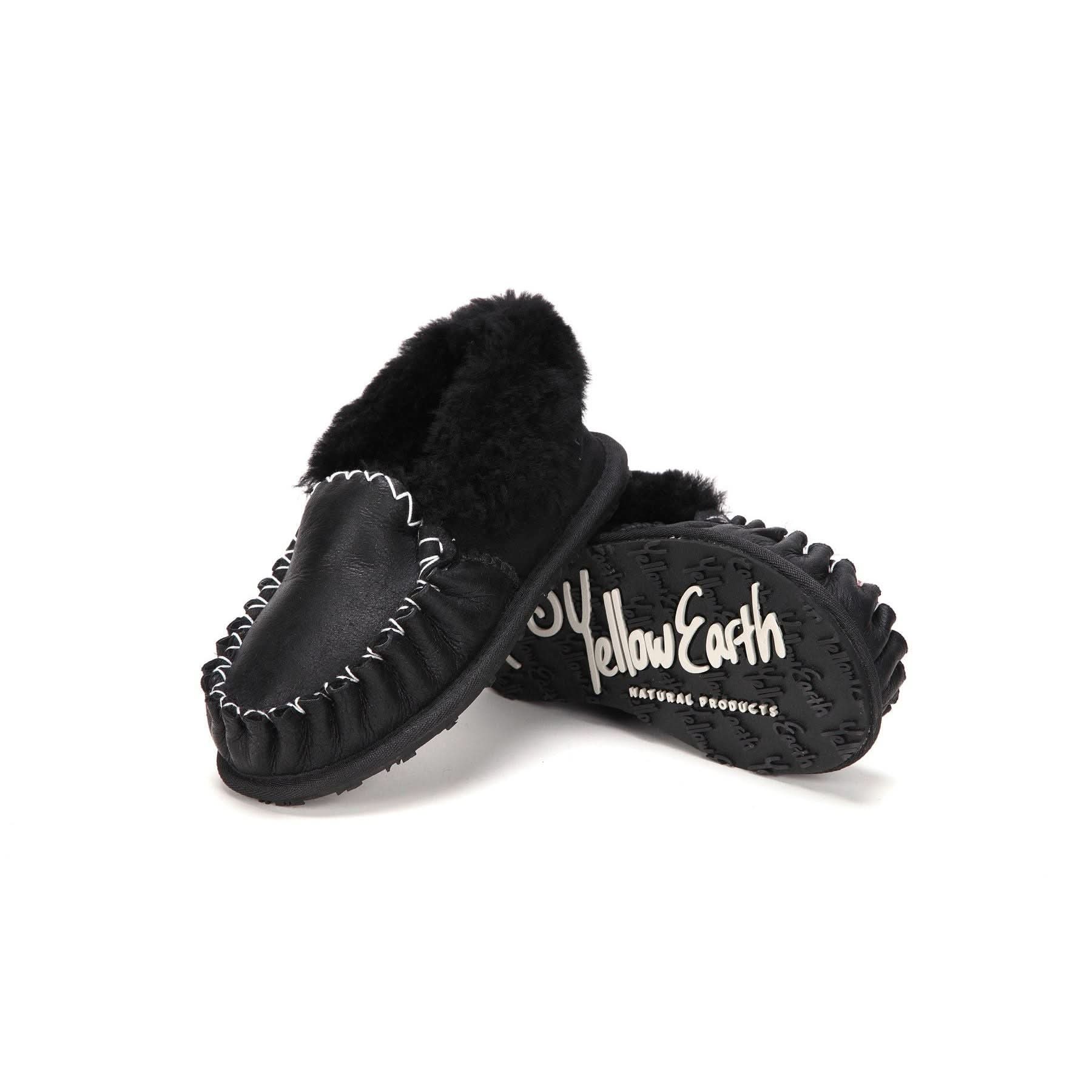 Black sheepskin moccasin slippers with fur lining shown from side angle displaying sole. - Yellow Earth Australia