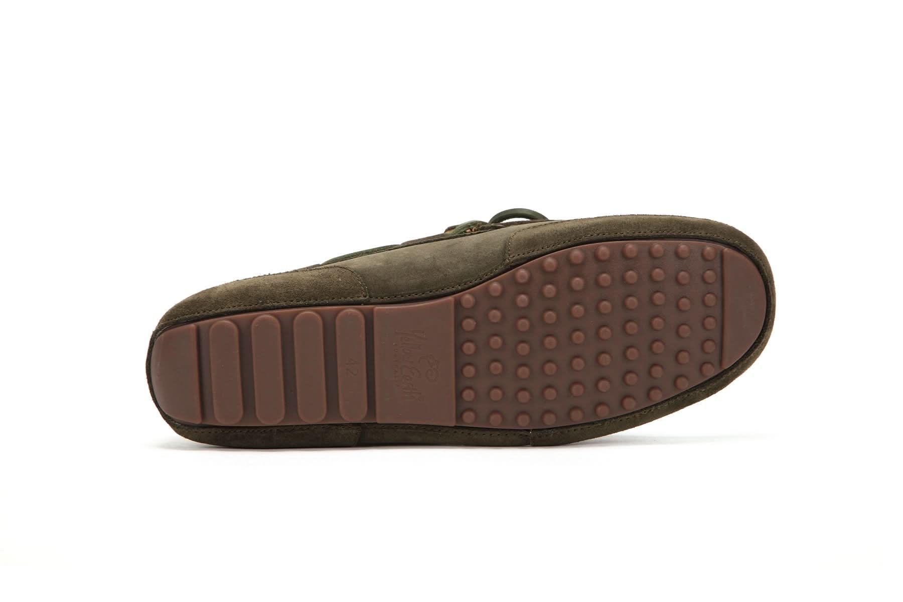 Brown rubber sole of a men's sheepskin moccasin slipper on a white background