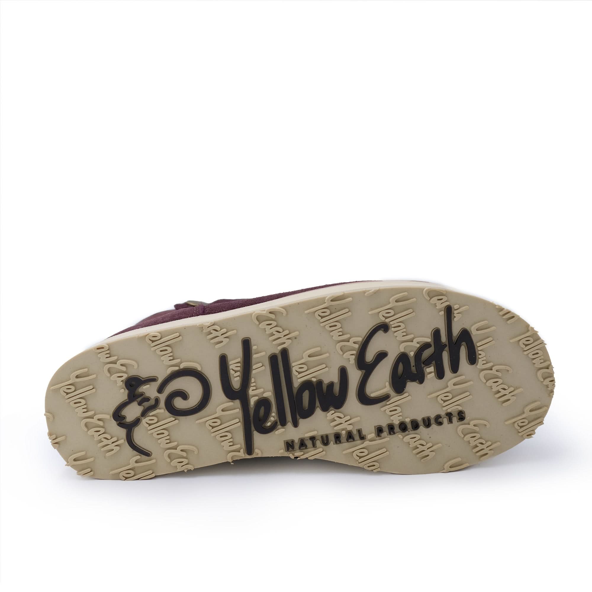 Sheepskin boot with tan sole showing 'Yellow Earth' logo and natural products text.