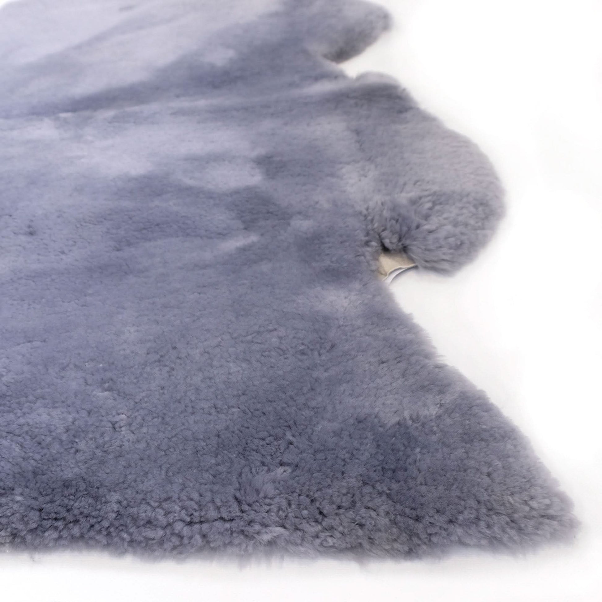 Grey sheepskin rug with soft wool pile texture shown from above on white background. - Yellow Earth Australia