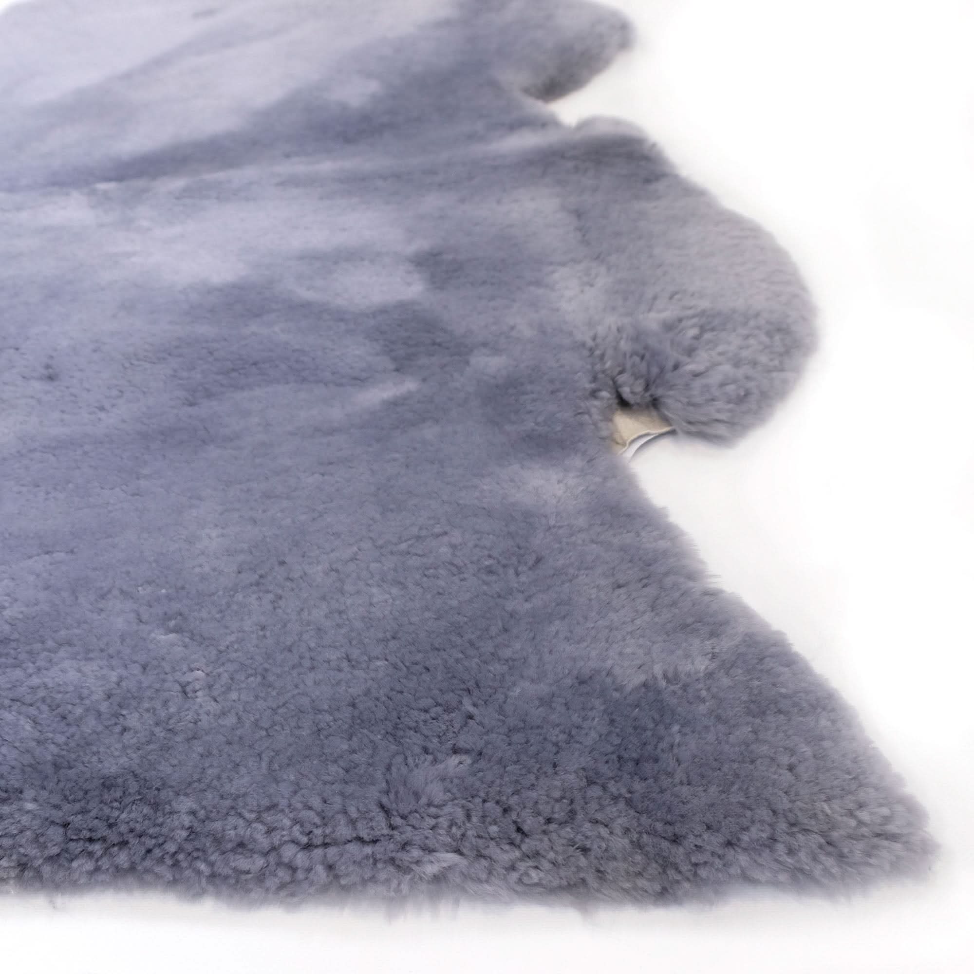 Grey sheepskin rug with soft wool pile texture shown from above on white background. - Yellow Earth Australia
