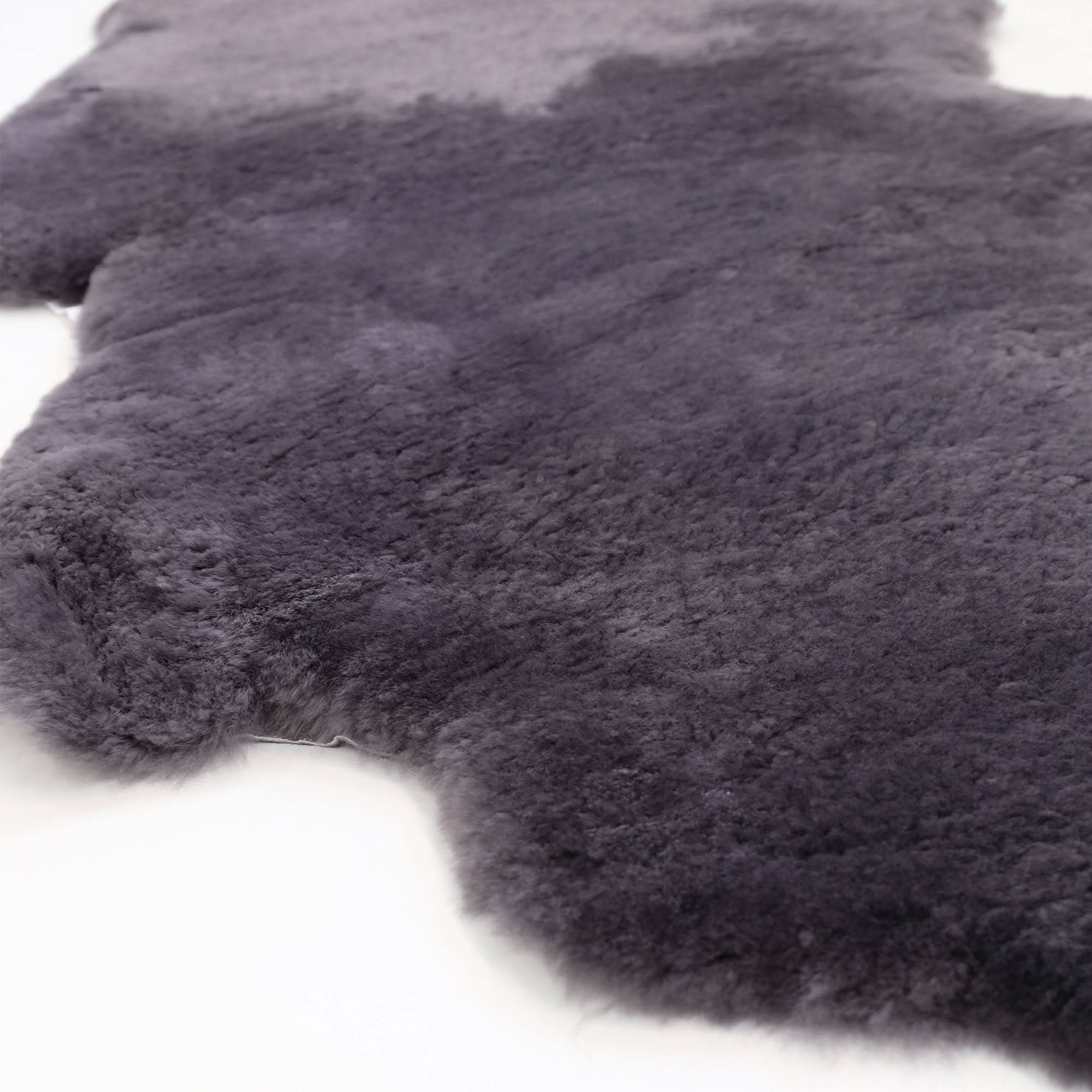 Charcoal grey sheepskin rug with luxurious wool texture on white background. - Yellow Earth Australia