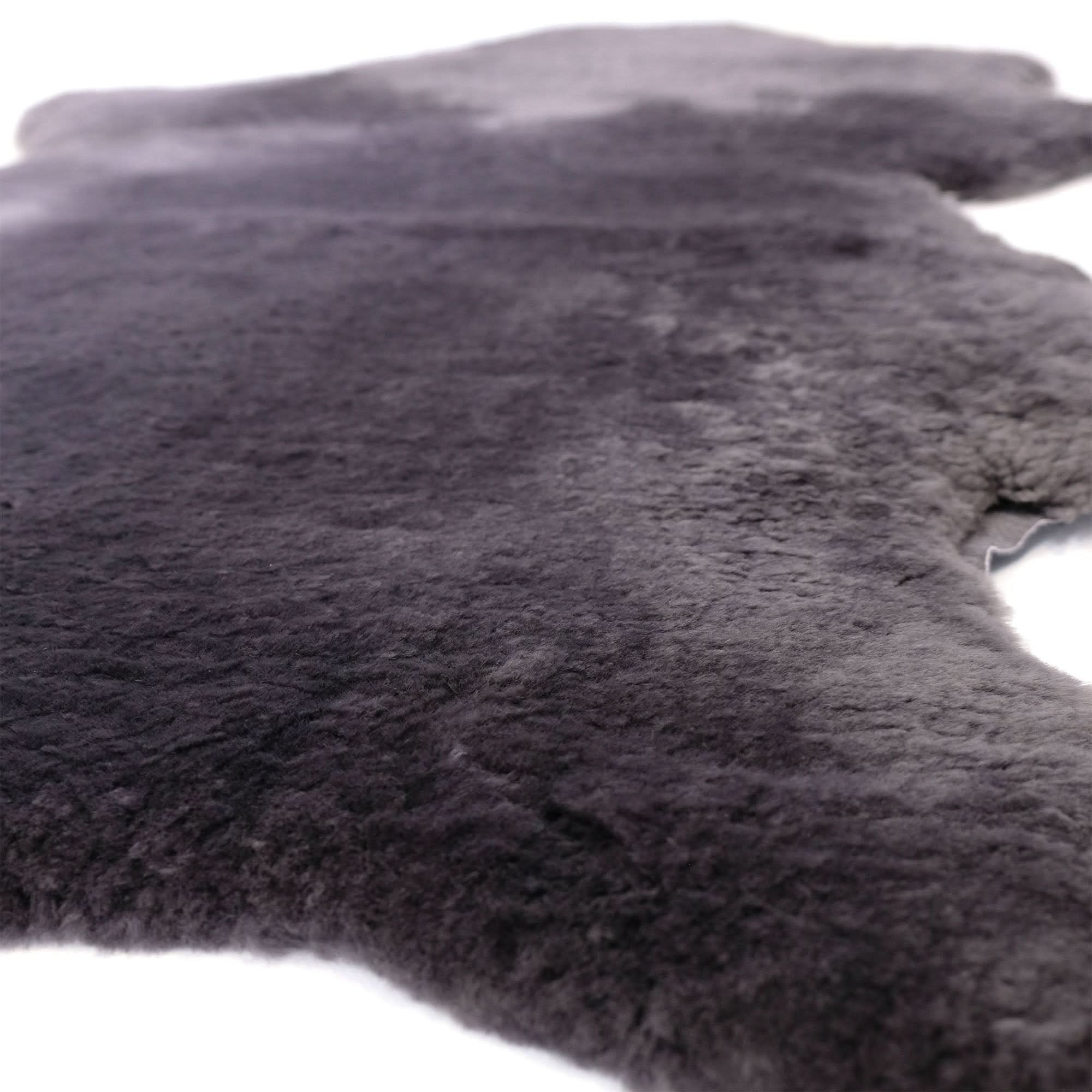 Grey sheepskin rug with thick wool pile viewed from angled top perspective. - Yellow Earth Australia