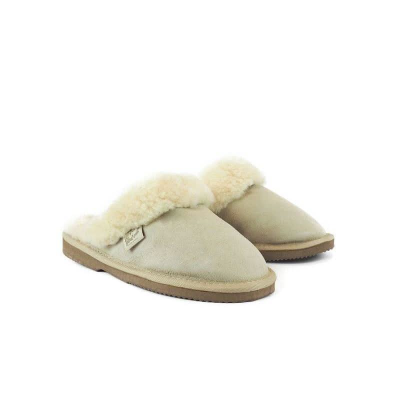Pair of cream sheepskin slippers with fluffy wool collar and tan suede sole, angled front view. - Yellow Earth Australia
